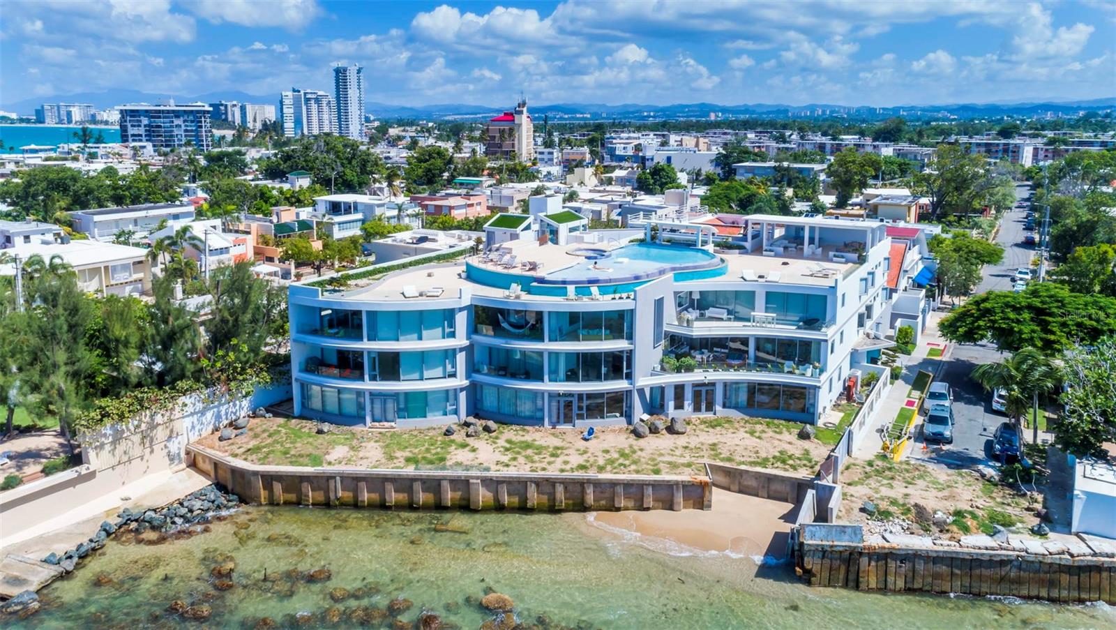 Understated luxury pervades the serenely elegant living environment, an inspired revelation of space, light, and form that balances grace and noblesse, boldness and restraint, rich complexity, and spare refinement. Welcome to Azure Beach at the gated Almendro Street in Punta Las Marias!
This spectacular oceanfront Penthouse conceived with contemporary architecture offering exceptional proportions and stunning views. The residence is exquisitely designed throughout 3,217 square feet, configured with three bedrooms each with a full bathroom, and a bonus room with a full bathroom, elegant marble floors throughout and a charming open terrace. The interior space exudes sophistication, combining comfort with style. The open floor plan seamlessly integrates the living, dining, and kitchen areas, creating a perfect environment for entertaining guests or enjoying quality family time. The fully equipped gourmet kitchen features sleek cabinetry and stainless-steel appliances.
Wake up to the gentle sound of waves and be mesmerized by the enchanting ocean vistas that stretch as far as the eye can see. The floor-to-ceiling windows and spacious terrace ensure that you will never miss the beauty of the surroundings.
Azure Beach is a resort-style development that would be impossible to duplicate today. Residents of Azure Beach enjoy the most impressive roof-top of any development in San Juan that includes an infinity pool and spacious open and covered terraces to entertain the most demanding guests. Seat and relax to witness dramatic sunrises and sunsets. The development offers a full power generator and water cistern.