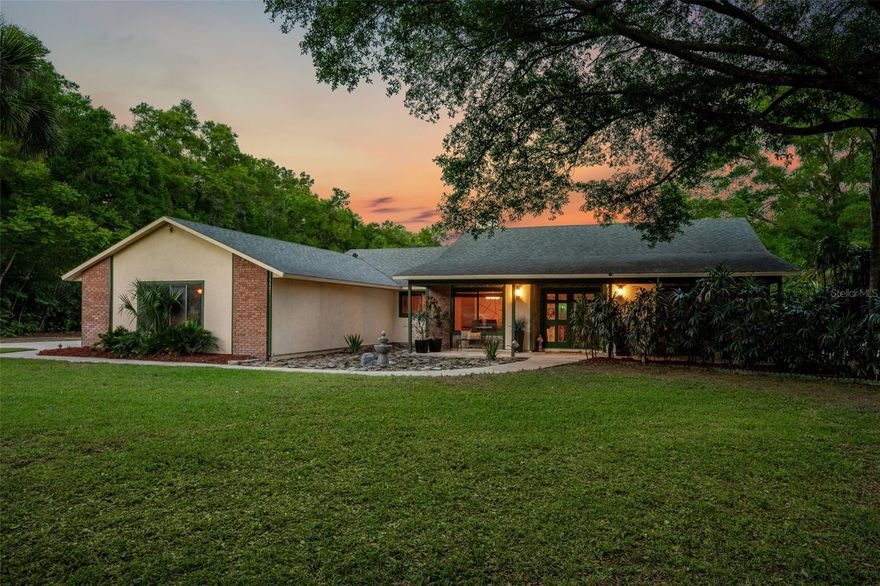 RARE OPPORTUNITY. Welcome to your private paradise! Perfect for families seeking space, freedom, privacy, and breathtaking sunsets, this recently appraised 2.5-acre fully fenced estate is located on a quiet cul-de-sac in the sought-after Spring Hollow community. Zoned P-D, the grounds showcase a peaceful natural setting surrounded by mature trees, tropical landscaping, and several large palm trees in the front yard.

The main residence offers 2,481 square feet of living space, featuring 4 bedrooms and 2.5 bathrooms, with a functional open-concept layout, volume ceilings, plenty of storage, natural light, a separate laundry room, and a spacious family room highlighted by a beautiful stone electric fireplace, ceiling fans installed in multiple areas, and a lifetime termite bond for peace of mind.

Major updates include a dimensional shingle roof replaced in 2018, exterior painting completed in 2025, PEX plumbing installed in 2015, updated HVAC condenser (2022), and a 200-amp electrical system with copper wiring.

The updated kitchen features cherry wood cabinetry, stainless steel appliances, decorative tile backsplash, stone flooring, wine station, and a functional gourmet layout ideal for everyday living and entertaining.

The spacious primary suite features a unique open-concept design completed in 2021, showcasing a freestanding soaking tub and walk-in shower integrated into the suite, creating a spa-like experience. This private retreat includes hurricane-rated double-panel windows and doors, a double vanity, a separate spacious custom walk-in closet with wet vanity included, volume ceilings, and abundant natural light. Three windows provide relaxing views of the outdoor setting, including a decorative waterfall and fire feature. A ceiling-mounted movie projection screen and projector are included in the sale.

Step outside into your private outdoor oasis, featuring a sparkling in-ground pool and spa with screened enclosure, self-cleaning system, salt system installed in 2024, updated filtration system in 2024, pool pump replaced in 2021, and pool renovation completed in 2025. The expansive screened patio includes a bar area ready for entertaining, with four convenient access points from the primary bedroom, living room, kitchen, and patio bathroom, perfectly positioned to enjoy stunning sunrise views.

The outdoor living experience continues with mature trees, tropical landscaping, an 8-foot fire pit, and a fixed gazebo with a metal roof, ceiling fan, and colorful lighting. A cozy secret garden adds another peaceful retreat. The fully fenced 2.5-acre property includes rear gates with independent entrances and an extended driveway.

Additional structures include a detached guest house converted from a barn, featuring 2 bedrooms and 1 bathroom, currently operating as an income-producing detached guest house.

For those needing additional storage or workspace, the property features a spacious 3-car attached garage equipped with new doors, replaced motors, new tracks, and new springs. In addition, a separate 20x40 RV/workshop garage offers exceptional versatility.

Additional features include two wells providing reliable water supply, eliminating water bills, and an all-new irrigation system.

Conveniently located near Wekiwa Springs State Park and the Apopka Amphitheater, with easy access to SR-429 and US-441, minutes from AdventHealth Apopka, and nearby shopping, dining, and outdoor recreational destinations.