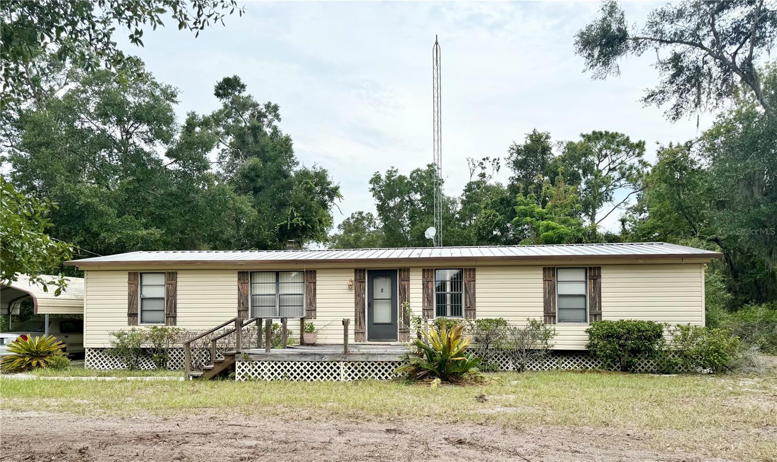 Like, Totally .... Home Sweet Home -80's Style. Crank up the cassette player and slip into nostalgia with this 1981 Peachtree model manufactured home. With 3 bedrooms, 2 baths and almost 1400 sq ft, this rad retreat has all the space you need to live your best throwback life! With some TLC it could be restored to its vintage glory! A great property for investors. Totally tubular features, such as a classic fireplace for cozy nights watching VHS tapes. Built in dinette in the kitchen because breakfast nooks were the spot in the 80's! Plush carpeted bedrooms, living room and dining room for authentic retro comfort. All bedrooms have walk in closets and two full airy bathrooms to spike your hair and saturate in Aqua Net! Indoor laundry room and utility area to wash your parachute pants and other neon fashions. Outside perks such as sturdy metal roof built to last, 420 sq ft workshop for hobbies, projects, or maybe your very own neon-lit arcade. Two car carport to keep your trans am protected. Spread out on the 2.46 acres of fresh air and elbow room. Directly across from Ochwilla Elementary, tucked off State Rd 21 and just a short cruise to Gainesville for shopping, dining, and all your modern convenience needs. This home is more than a blast from the past, it's a rare chance to own a piece of retro charm with todays comfort. So tease up that hair, dust off the boom box, and make this 80's classic yours.