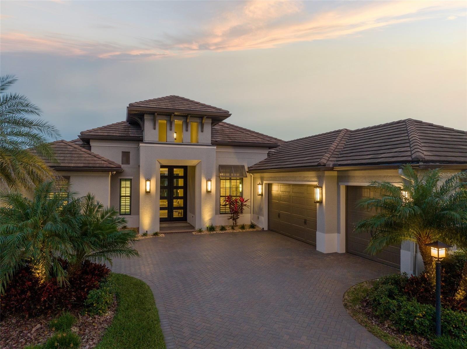 Experience the pinnacle of luxury living in this beautifully appointed Arthur Rutenberg residence located in Lakehouse Cove at Waterside. Walking through the over 10' double iron door, you will be greeted by a serene water view that serves as a captivating backdrop throughout the home. The open floor plan begins with the great room that features rich wood flooring, automatic blinds, 12' ceilings, and impact-rated retractable sliding glass doors that open to an outdoor oasis. Outside, you will be enamored by upgraded palms that beautifully frame the water view, a heated saltwater pool with a hot tub and sun shelf, an outdoor kitchen, and entertaining spaces all complete with beautiful travertine flooring. Back inside the home, you will find a gourmet kitchen that is expertly equipped for entertaining with upgraded appliances by SubZero and Monogram, an expansive center island with seating, hidden pantry, gas cooktop, and a bar area with beverage center. The private master’s retreat offers large his and her walk-in closets, custom window treatments and intricate ceilings. In the connecting primary bath you will find a large soaking tub, dual vanities, and a spa shower with multiple shower heads. Quietly positioned on the other side of the home, there are two quality-sized bedrooms with walk-in closets and two full bathrooms. Further enhancing the comfort of the space, you will find a bonus room that overlooks the beautiful water view and features upgraded built-ins. Meeting today’s demands of versatility, there is also a separate designated office space that ensures you have the space you to need to fulfill your work-life wellness balance. The home is equipped with a whole house generator and impact windows and doors throughout, providing peace of mind. Other notable features include: three-car garage with epoxy flooring, whole-house water filtration system, room-to-room sound system, large laundry room, royal palms, landscape lighting and a security system with cameras. Lakehouse Cove offers resort-style living at a community level where residents enjoy a large amenity center with pickleball, a playground, dog parks, state-of-the-art gym, social activities, and pool and spa overlooking the lake where you can kayak or take a water tax to Waterside Place! HOA includes all landscaping. If you are looking for a move-in ready home by a premier builder that features exquisite finishes throughout - this is it! Bedroom Closet Type: Walk-in Closet (Primary Bedroom).