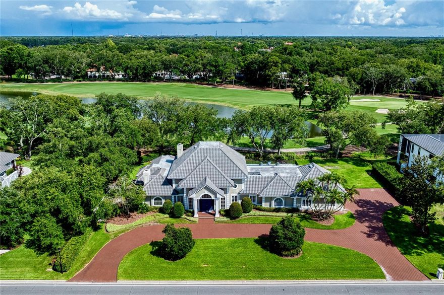 Welcome home to this magnificent estate in Avila, Tampa Bay’s premier guard-gated golf and country club community.  Perfectly positioned along the 16th tee box with a view of the fairway and the green of 15, this exceptional residence boasts an impressive 205 feet of golf course frontage and showcases sweeping panoramic views that create a truly breathtaking backdrop. Featuring 6,789 Sq Ft this custom designed estate features 4  bedrooms, (Primary bedroom and guest bedroom on the first floor and 2 additional ensuite bedrooms on the 2nd floor) 5 full bathrooms, 2 half bathrooms, home office/library, and the most gorgeous new swimming pool, spa and outdoor fireplace.  Designed for both elegant entertaining and everyday living, the home seamlessly blends timeless architecture with luxurious comfort. Upon arrival, you will be impressed by the exceptional curb appeal of this estate, enhanced by beautifully landscaped grounds and a circular driveway that creates a welcoming first impression. The elegant foyer sets the stage for the thoughtful architectural details and quality craftsmanship that are showcased throughout the home. The library/office features custom-designed built-in cabinetry, a fireplace, and a coffered ceiling. Designed for effortless entertaining, the formal dining room is accented by a built-in buffet, decorative lighting, stately columns, and a beautifully detailed coffered ceiling, creating a refined setting for gatherings with family and friends. The family room includes custom built-in cabinetry, a fireplace, and an adjoining bar, offering the perfect setting for relaxation and entertaining.  Sliding glass doors open to the outdoor living areas, creating a seamless transition to your private backyard oasis. The sun-filled kitchen is both beautiful and functional, featuring custom cabinetry, granite countertops, stainless steel appliances and abundant workspace for meal preparation. An adjoining casual dining area provides the perfect place for everyday meals while offering views of the surrounding outdoor landscape. The main-level primary suite is a true owner's retreat, offering exceptional privacy and comfort. Complete with separate his-and-her bathrooms, this inviting sanctuary provides the perfect place to relax and unwind. Completing the first floor is an additional ensuite guest bedroom which is ideal for family and guests. Upstairs you will find 2 spacious bedrooms each with their own private bathroom and a walk in closet. Step outside and discover an extraordinary outdoor retreat highlighted by a spectacular newly constructed swimming pool and spa, creating the ultimate setting to relax, entertain, and enjoy the beauty of your surroundings. With its unparalleled setting, exceptional amenities, and stunning golf course views, this remarkable residence in Avila offers a lifestyle that is simply beyond compare.