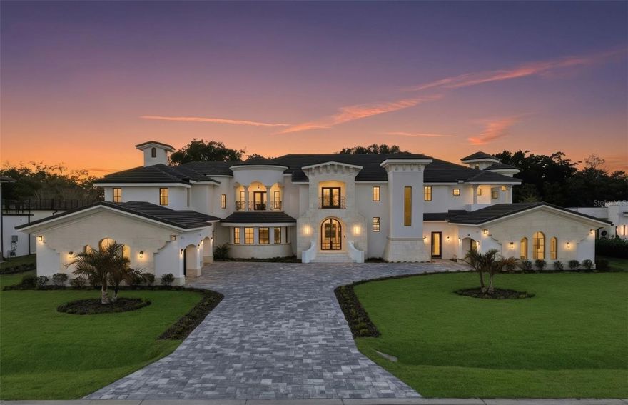 One or more photo(s) has been virtually staged. Just completed | Never lived in | A rare opportunity to be the very first to call this architectural showpiece home! Positioned in the highly sought after Lake Down Reserve community of Windermere, this custom-built modern Mediterranean estate delivers nearly 8,000 square feet of elevated design, cutting-edge construction, and curated luxury. Built by Supreme International Construction – one of Windermere’s most respected luxury builders – this home is a true statement of craftsmanship and innovation. From the hollow-core concrete second floor to level five interior walls, hurricane-impact windows and doors, and comprehensive low-voltage wiring, every structural detail reflects next-level quality. Inside, the open-concept floor plan unfolds with dramatic scale and natural light, anchored by a show-stopping LED-lit staircase and seamless indoor-outdoor flow. The chef’s kitchen is outfitted with premium Wolf appliances, custom cabinetry, and refined finishes that balance timeless elegance with modern edge. Designed for both grand entertaining and private retreat, the home features: 5 spacious bedrooms | Dedicated executive office | 6 full baths and 2 half baths (each bath appointed with luxury bidets) | Custom California Closets throughout | Elevator access for effortless convenience | Oversized 4-car garage. A rare “bonus basement” level adds additional flex space – perfect for a media lounge, in-law suite, wine cellar, game room, or collector’s showcase. Outside, enjoy balcony views of Lake Down and a resort-caliber backyard that includes a custom pool and spa, a dramatic sunken outdoor kitchen, fire-pit and expansive entertaining terraces designed for unforgettable evenings under the Florida sky. Lake Down Reserve offers expansive homesites, 24-hour virtual guard security, zoning for top-rated schools, and proximity to fine dining, championship golf, world-class shopping, and Orlando’s renowned attractions – all while still preserving the privacy and tranquility that define Windermere living. This is more than new construction. It is a fully realized modern estate – bold, refined, and built for the most discerning buyer. Welcome to your legacy home!