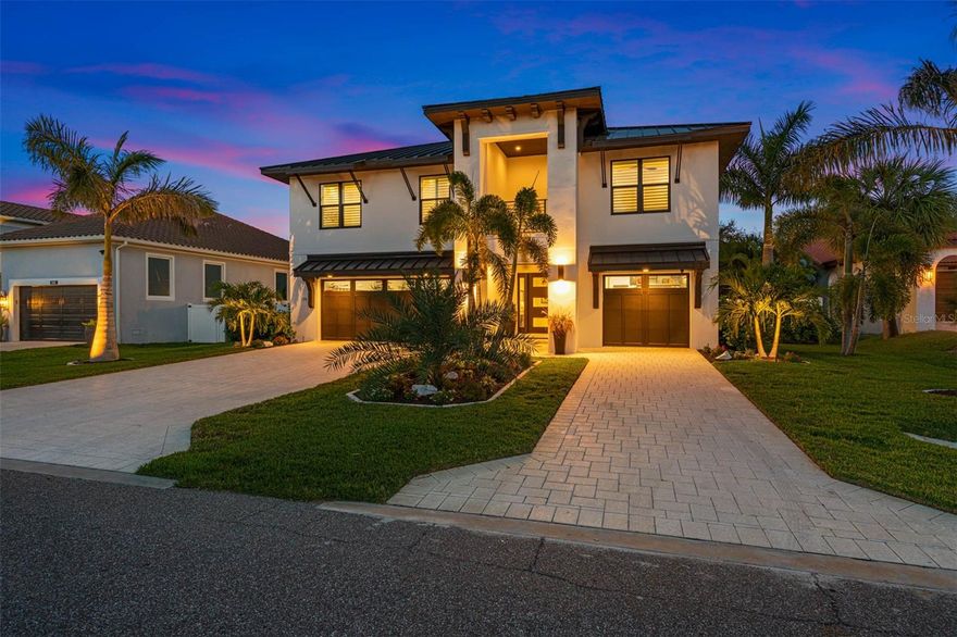 This stunning modern home, built in 2021 by JR Structures, makes an impression the moment you set foot on its grounds. Spanning 6720 square feet under roof, it stands proudly among the prestigious waterfront estates on one of Tierra Verde's most sought-after streets. Boasting 4 bedrooms , 3.5 baths, ample storage, a 4-car garage with the option for additional space, workshop, boat storage, and a saltwater heated swimming pool, this residence seamlessly blends impeccable design with inviting warmth, catering perfectly to both growing families and professionals in need of office space.  Step into the foyer, bathed in natural light, where an elevator or staircase leads to the expansive living area featuring 10’ wide-plank oak flooring and luxurious finishes throughout. The gourmet kitchen is a chef's dream, equipped with top-of-the-line Subzero/Wolf appliances, an oversized quartz island, Wolf GAS stove, double oven, custom cabinetry, and a built-in sweep vac. For added convenience, a walk-through pantry and an upper attic space provide an extra 2500 square feet of storage. The living room, seamlessly connected to the kitchen, offers a chic yet cozy ambiance with built-in TV and shelving, while double-stacked sliding doors open onto the covered patio. With the touch of a remote, the patio can be fully screened for enhanced comfort. Each bedroom is generously sized, with the primary suite featuring a large walk-in closet, luxurious bathroom with freestanding soaking tub, and double shower.  Additional features include central vac throughout, hot water on demand, reverse osmosis water system, custom extra-wide spiral staircase connecting the two levels, undercounter ice maker, home workshop, outdoor lighting, sprinkler system, acoustic ceiling, and epoxy flooring. This home is not only luxurious but also practical, with climate-controlled attic storage, spray foam insulation, and enhanced storm-proofing details.  Situated on nearly 10,000 square feet of prime real estate, the property offers glimpses of water from the front patio and stunning western sunsets over Pass-A-Grill channel. Watch Cape Canaveral launches from the eastern-facing lanai. Located in the coveted community of Tierra Verde, residents enjoy easy access to Port 32 Marina, Ft. De Soto Park and beaches, Shell Key, and St. Pete Beach, just a 5-minute drive away.   Experience the epitome of luxury living in Tierra Verde—schedule your private tour today and make this exceptional home your own.