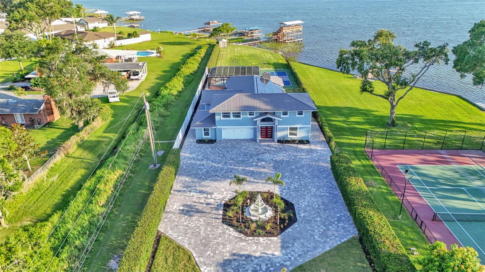 Welcome to 390 Windermere Drive, a stunning lakefront estate in the heart of Lakeland. Meticulously updated and designed with luxury in mind, this 5-bedroom, 6-bathroom residence offers over 3,500+- square feet of beautifully finished living space—perfect as a primary residence, vacation retreat, or investment property. It sits on just under 1 acre and is a private waterfront getaway.
From the moment you arrive, this property makes a statement. A gated entrance opens to a custom brick driveway and landscaped island, framed by lush privacy hedges. A spacious two-car garage and separate golf cart garage provide ample storage for vehicles and recreational gear.
Step inside to discover a bright, modern interior with high-end porcelain flooring, a dramatic custom staircase, and soaring ceilings. The open-concept kitchen and living area is an entertainer’s dream, featuring tray ceilings, elegant chandelier lighting, magazine-worthy finishes, and top-tier appliances. Adjacent is a formal dining area and additional dinette—ideal for prep or informal meals.
The home offers three luxurious bedroom suites with private baths, a dedicated office, and a second-floor balcony with stunning lake views. Every detail has been thoughtfully curated, including recent updates to the roof, windows, doors, and systems throughout.
The outdoor living space is nothing short of a private resort. Enjoy the screened-in heated pool, a dry sauna, and an outdoor bathroom—all under a covered lanai. Beyond the pool area, you'll find your own private sports complex with a pickleball court, fully fenced for added privacy.
What truly sets this home apart is the two-level dock, complete with a boat lift, jet ski lift, and covered balcony overlooking beautiful Lake Gibson—perfect for sunset cocktails or early morning coffee. With 58 fully owned solar panels, this home offers energy efficiency you will appreciate.
Located just minutes from I-4, top-rated schools, shopping, and dining, and an easy drive to both Tampa and Orlando, this home offers the best of lakefront living with modern convenience.
Don’t miss the opportunity to own one of Lakeland most exceptional waterfront properties.