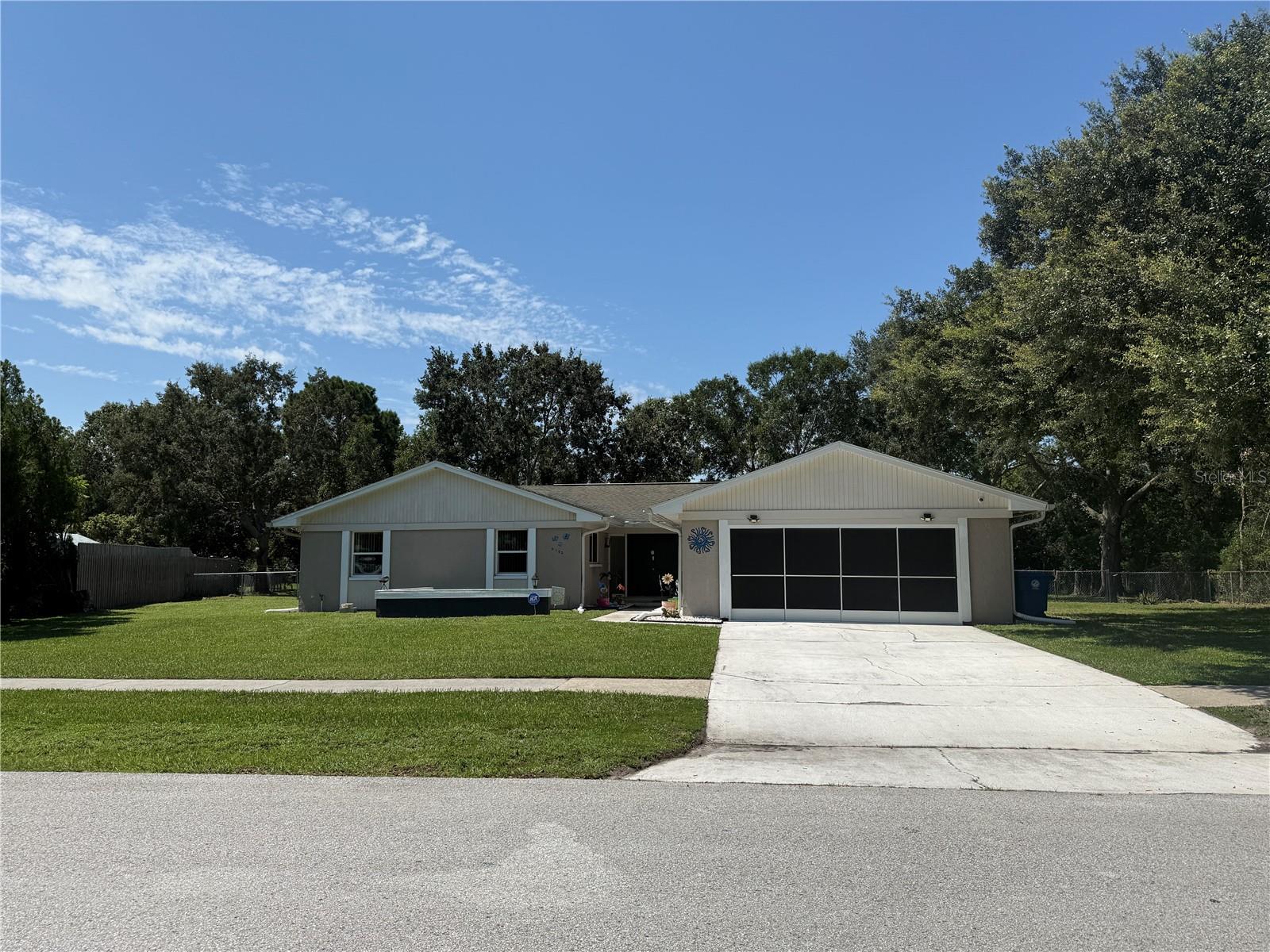 Looking for extra space? This 4-bedroom, 2-bath home sits on just under a half-acre with a beautiful lake view—right in the heart of the city! With no HOA, no deed restrictions, and the convenience of public sewer (no septic!), this property gives you the freedom you want and the room you need. Step inside through double front doors to an open, light-filled floor plan. The spacious living room features sliding glass doors overlooking the lake, while the split-bedroom layout provides privacy for everyone. The primary suite offers a walk-in closet, an updated en-suite with double sinks, and a recently remodeled shower. The secondary bath has also been stylishly updated. The kitchen has been tastefully remodeled with newer cabinetry, stainless steel appliances and updated finishes. Other highlights include scraped ceilings, updated baseboards, and sliding glass doors from both the dining and living rooms. Enjoy Florida living outdoors with a large screened patio (complete with ceiling fan), a pavered BBQ patio, and a fully fenced yard. The oversized 2-car garage features a sliding screen, plus there are RV hookups for your toys. This home truly offers elbow room with modern updates—plus a serene lake view! Don't wait and schedule your showing today!