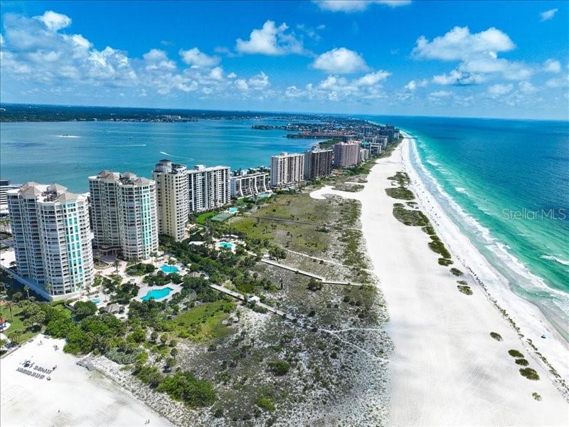 Welcome to your dream coastal retreat at The Grande! This exquisite luxury condo offers everything you’ve been searching for. Located on the stunning shores of Sand Key, you’ll be captivated by its resort style amenities and the awe-inspiring sunsets! Step inside and experience the epitome of elegance and comfort. The open floor plan creates a seamless flow between the living, dining, and kitchen areas, perfect for entertaining. The expansive windows and walls of hurricane sliders with low-E sun reflecting glass allow natural light while offering panoramic views of the glistening pool and pristine beach beyond. Indulge in the sanctuary of the spacious primary bedroom, complete with a luxurious ensuite bathroom. Designer finishes adorn every corner of this magnificent home from the beautiful floors to the custom cabinetry, every detail has been curated to create a space that is both visually stunning and functional. The beautiful dine-in kitchen features custom cabinets, stainless steel appliances, an island with breakfast bar and a wine fridge with a pass through. The spacious guestrooms ensure that your loved ones will always have a comfortable place to stay. Plus, the semi-private elevator adds an extra touch of exclusivity and convenience. Imagine waking up to the sound of waves and stepping onto your private balcony to greet the day. Spend lazy afternoons lounging by the pool or taking a leisurely stroll on the sugar-white sands. The Grande is just finishing a major update to ensure the future integrity and beauty of the property and all the assessments are paid. Conveniently located to local restaurants, boutique shops and more! Please note the garage is not included but available for purchase with sale.