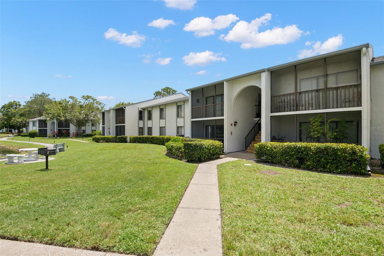 Peaceful Pond Views & Easy Florida Living in Tarpon Springs!
Welcome to this charming 2-bedroom, 2-bath condo, perfectly situated to capture serene pond views and embrace a relaxed, low-maintenance lifestyle. From the moment you enter, you’ll appreciate the open-concept design that blends the living room, dining area, and kitchen—ideal for both entertaining and everyday comfort.
The bright and airy living space is enhanced by sliding glass doors that lead to a screened-in lanai overlooking the tranquil pond—your own private retreat to enjoy morning coffee or evening sunsets. The dining area easily accommodates a full-size table and is highlighted by a stylish hanging light fixture.
The kitchen offers generous counter space with stone countertops, ample cabinetry, and a versatile nook—perfect for a breakfast area, home office spot, or additional storage. Down the hallway, a convenient laundry room includes a full-size washer and dryer plus built-in shelving.
The guest bedroom is well-sized with a large window and wall-to-wall closet, located just steps from the guest bath featuring a tub/shower combo. Tucked at the back of the home is your private primary suite, complete with a walk-in closet and an en suite bath with a step-in shower.
Community amenities include a sparkling swimming pool, clubhouse, tennis courts, and scenic walking trails. One of the community’s highlights is the path from your building to the pool—just a short, peaceful walk along the water.
Located in the heart of Tarpon Springs, you’re just minutes from Tampa Road, shopping, restaurants, and a quick drive to the Gulf beaches and downtown Tampa. Highly rated East Lake High School is located a stone throw away - a short walk and your are there!
Whether you're seeking a full-time residence, seasonal getaway, this condo offers comfort, convenience, and natural beauty in one exceptional package. Schedule your private tour today!
