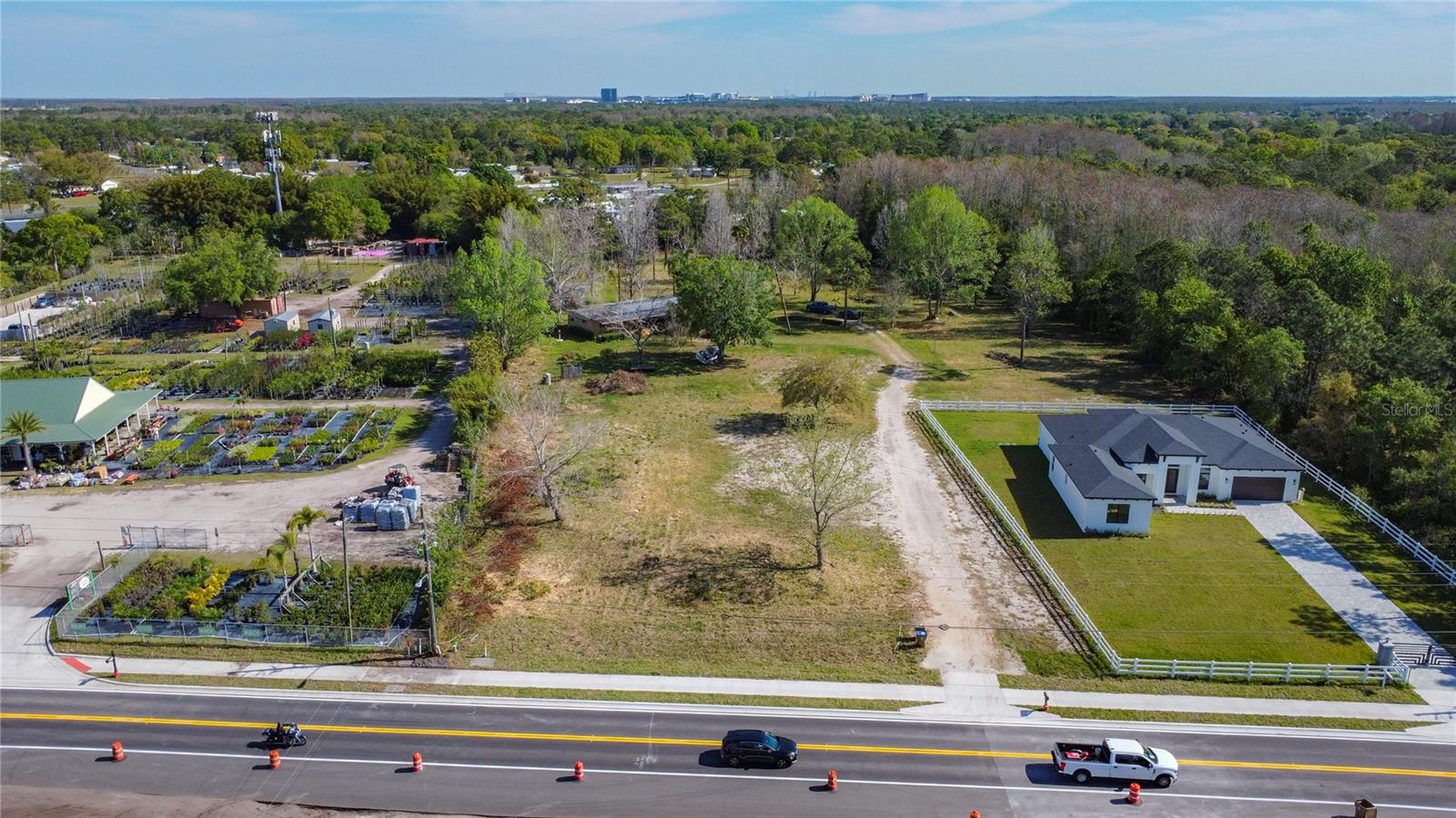 It is an excellent opportunity to own around 5 acres of scenic property in a prime area of Orlando International Airport , Lake Nona and Medical City, offering excellent development potential. Then next door property 3429 Boggy Creak is a brand new house also for sale by the same sellers. You can buy both properties together. Homesite includes a double-wide home w/addition, an expansive covered front porch, and oversized screened lanai. . This area is bathed in light, thanks to the two sets of sliding doors that open onto the lanai. Modern prep kitchen has plenty of storage space and room to seat. An addition to the back provides versatile space ? set up as a secondary entertainment center ? and leads directly to the backyard. This addition also includes an expansive laundry room, complete with shelving and cabinets to assist with your storage needs. Home has two bedrooms, with lovely porch views. Master suite has a contemporary ensuite bath and two walk-in closets. An additional large utility building w/electricity that will fit all sorts of vehicles (cars, boats, lawn equipment). It includes a storage room, and there is plenty of room to set up a workshop. There is a private pond/water view, and wooded views around the perimeter .This property can be easily change the zoning for multiple usage . Come see all that it has and make your own new memories ?