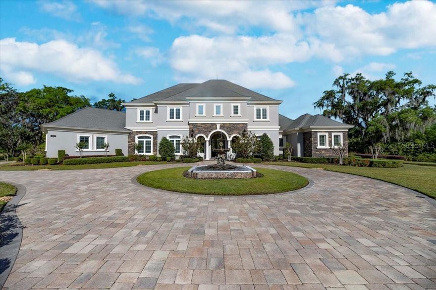 **A Masterpiece of Architectural Grandeur in Canterwood**  
BRAND NEW ROOF 7/2025

Nestled within the highly desired, gated enclave of Canterwood, 460 Canterwood Drive stands as an opulent testament to masterful craftsmanship and timeless elegance. Conceived by the esteemed Olivera Construction in 2010, this palatial estate sprawls across 2.25 meticulously landscaped acres, enveloped by the tranquil embrace of an HOA-maintained pond.  

Upon entry, a grand foyer welcomes you with soaring ceilings and a breathtaking wrap-around cascading staircase, an architectural marvel that gracefully ascends to the second-floor loft enhanced with a built in sauna for the health enthusiast. This dramatic entry sets the tone for the home’s unrivaled sophistication, where over 6,300 square feet of living space is designed to accommodate both intimate gatherings and grand-scale entertaining. Five lavishly appointed bedrooms, an executive office, and an inspiring art studio offer both sanctuary and space, while a floor plan tailored for multiple living arrangements ensures versatility without compromising luxury.  

At the heart of this estate lies a chef’s kitchen, where culinary aspirations meet professional-grade appliances, custom cabinetry, and seamless flow into the expansive living areas. The game room, complete with a bar, boasts an oversized balcony, offering a stunning vantage point to take in the serene landscape. Both the game room and the family room feature corner sliding glass doors that vanish when opened, dissolving the barrier between indoors and out, and creating an unparalleled entertaining experience.  

Step outside to a private resort, where a sprawling saltwater pool and hot tub—enhanced by a cascading waterfall and exhilarating slide—invite endless relaxation and recreation. With 9,500 square feet under roof, this estate masterfully blends indoor opulence with outdoor splendor, ensuring every space is as captivating as it is functional.  

A home of this caliber is not merely a dwelling—it is an experience, a statement, a legacy. Behind the exclusive gates of Polk County’s most coveted community, 460 Canterwood Drive stands as a beacon of luxury, ready to welcome its next discerning steward.