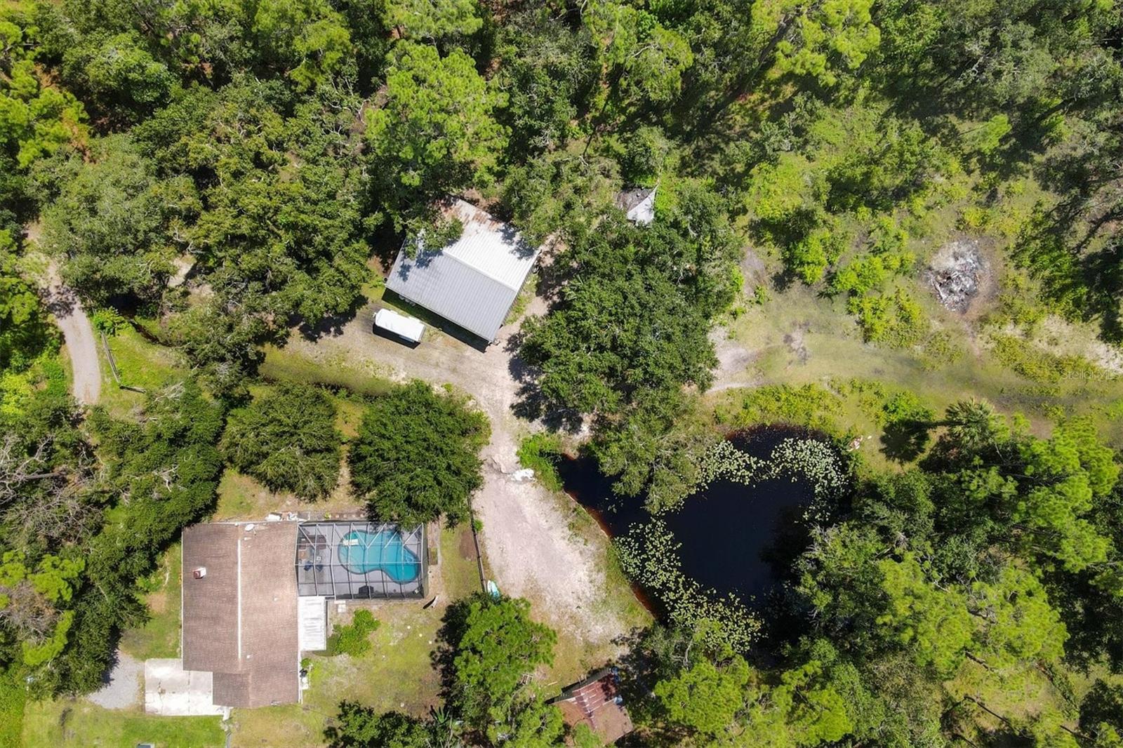 Horse-Friendly 10+ Acre Farmstead with Home, Pool & Stables in Parrish, FL Tucked away on a private drive, this 10.46-acre farm offers the rare blend of country tranquility and convenience, just minutes from Sarasota, Tampa, Lakeland, and Orlando. With an “Old Parrish” feel and abundant wildlife, the property is ideal for those seeking space, privacy, and equestrian amenities. The three-bedroom, two-bath home is thoughtfully designed for comfort, featuring a cozy front porch, a back screened porch, and a recently resurfaced pool with screened lanai—perfect for both relaxation and entertaining. Practical upgrades include an instant kitchen sink water heater with alarm (2020), HVAC system (2021), roof (2012), and spray fluff attic insulation for efficiency. Horse enthusiasts will appreciate the stables, riding ring, tack room, feed room, pole barn, and a well-equipped workshop. Two ponds add to the natural beauty, while the property extends beyond the wooden fencing to a wire boundary, offering even more usable land. An insulated garage with laundry adds versatility and functionality. Whether you’re caring for horses, enjoying the wooded trails, or watching local wildlife, this farm offers the peaceful lifestyle many dream of. Zoned for Parrish High School, it combines rural charm with everyday accessibility. Wooded setting full of wildlife. Zoned Parrish High School. Current kitchen appliances remain in the home, including the Wine Refrigerator.