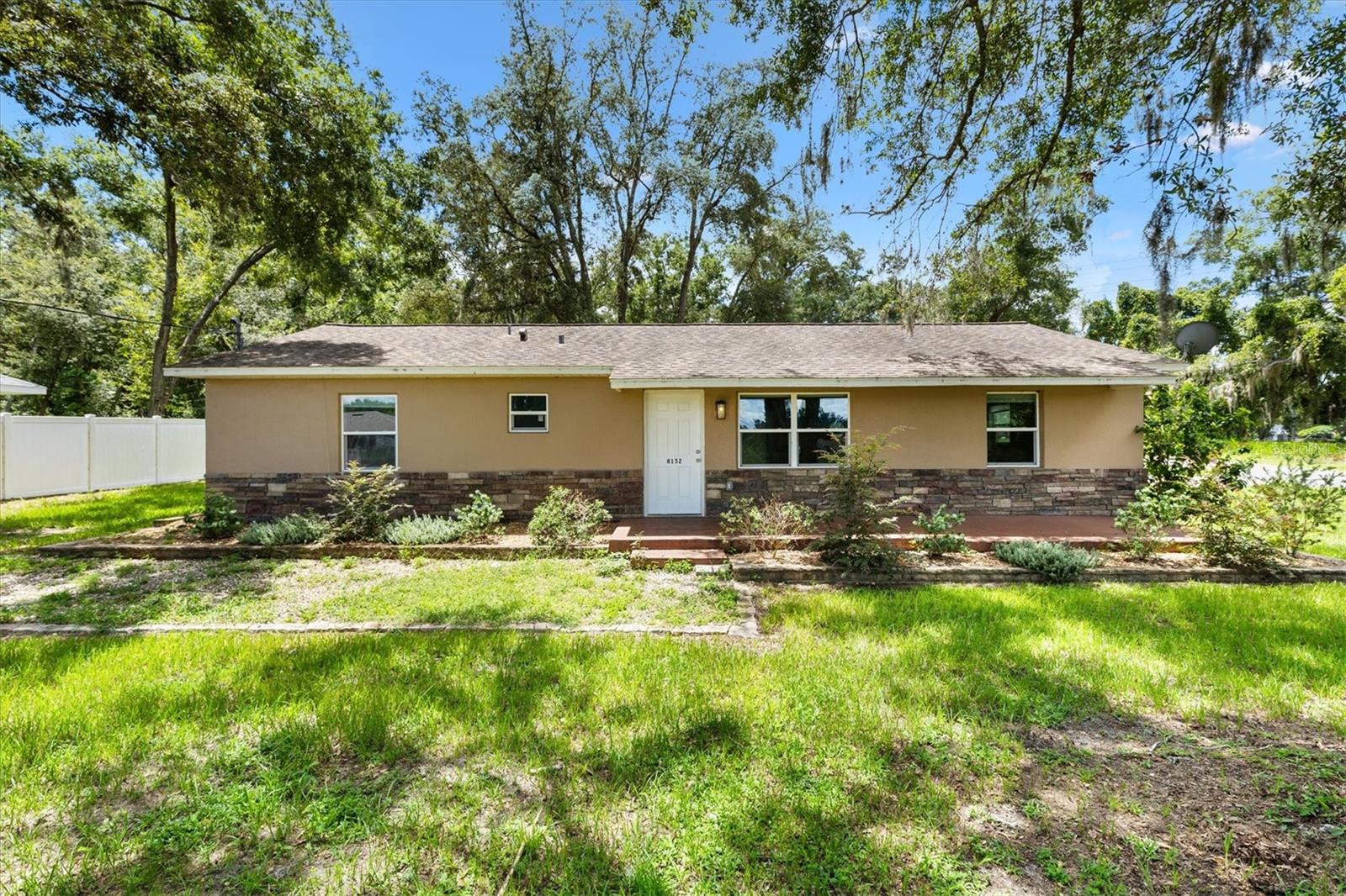 Welcome to this beautifully RENOVATED 2BR/2BA home that perfectly blends modern comfort with a touch of country charm. Situated on an oversized 0.29-acre lot, this property offers both space and convenience, located just minutes from The Villages, Ocala, shopping, dining, and more. Inside, you’ll find 1,300± sq. ft. of thoughtfully renovated living space featuring recessed lighting, durable LVP flooring, and a spacious kitchen with shaker cabinetry, granite countertops, stainless steel appliances, and a cozy dining nook. The master suite offers a walk-in closet and a spa-inspired ensuite with a beautifully tiled shower, while the generous guest bedroom is served by a stylish hall bath. Additional highlights include an inside laundry room, carport, fenced yard, and a stunning outdoor living area complete with a paver patio and stone veneer accents that enhance the home’s curb appeal. With its prime location, oversized lot, and tasteful upgrades, this property truly has it all. Don’t miss your chance—schedule a showing today!