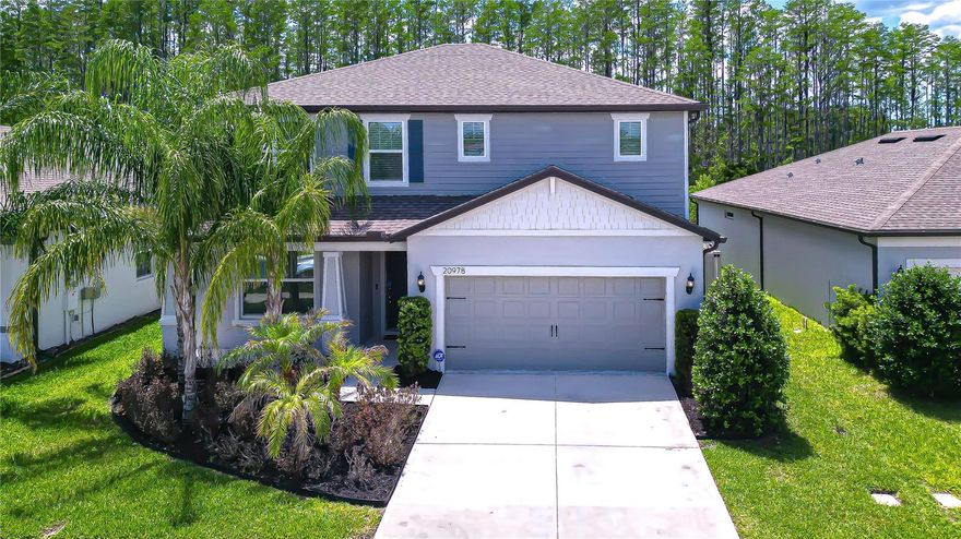 Welcome to 20978 Monza Loop in the GATED COMMUNITY of Arden Preserve, where the major expenses of new construction have already been handled for you. Built in 2022, this home delivers immediate value with NO CDD fees and includes upgrades that typically cost thousands more through a builder, such as a FULLY VINYL FENCED backyard, EXTENDED PAVER PATIO and walkway, window blinds and curtains, and a fully owned WATER TREATMENT SYSTEM. Located in FLOOD ZONE X, it also offers the added benefit of potentially LOWER INSURANCE COSTS, making this a smart move both upfront and long-term. Inside, the home offers 4 bedrooms, 2.5 baths, and 2,386 square feet of thoughtfully designed living space with a BRIGHT, OPEN-CONCEPT layout. The main level is filled with NATURAL LIGHT and features a seamless flow between the living, dining, and kitchen areas, creating an inviting space for both everyday living and entertaining. The kitchen is anchored by a LARGE CENTER ISLAND with seating, complemented by sleek countertops, stainless steel appliances, ample cabinetry, and modern pendant lighting. Sliding glass doors open to the COVERED LANAI, enhancing the indoor-outdoor connection. Upstairs, a spacious loft provides FLEXIBLE LIVING SPACE for a second living area, media room, or home office, while the generously sized bedrooms offer comfort and privacy. The primary suite serves as a relaxing retreat with an en-suite bath featuring dual vanities, a walk-in shower, and plenty of storage, and a dedicated laundry room adds convenience. Out back, the covered lanai overlooks a PRIVATE YARD that backs to PEACEFUL GREENSPACE with NO REAR NEIGHBORS, creating a quiet setting to relax or entertain. The extended paver patio expands your outdoor living options, whether you’re hosting gatherings or simply enjoying the Florida lifestyle. Arden Preserve is a fully completed gated community with no ongoing construction, offering a more established and peaceful environment. Residents enjoy a PRIVATE WALKING PATH leading directly to Land O’ Lakes High School, a community dog park, and convenient access to nearby shopping, dining, and major roadways. This home combines modern construction, functional living space, and meaningful savings in one of Land O’ Lakes’ most desirable neighborhoods.
