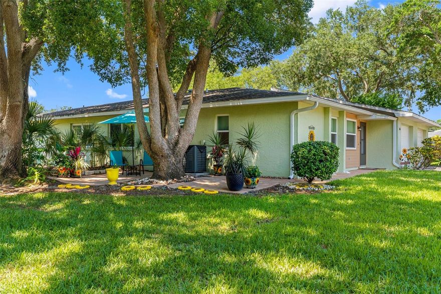 Welcome to maintenance-free living in the desirable 55-plus community of Orange Tree Villas in the heart of Palm Harbor. Tucked away at the rear of the community, this charming two-bedroom, two-bath end unit villa offers exceptional privacy surrounded by lush natural scenery. Relax on the spacious side paver patio while enjoying peaceful views of nature and frequent deer sightings in this quiet, quaint neighborhood. This light and bright villa features an attached one-car garage and is in a non-evacuation zone. From the moment you arrive, you’ll appreciate the storm door entry and updated garage door. Inside, natural light highlights the beautiful wood-look tile flooring, crown molding, fresh interior paint, and cozy electric fireplace that creates a warm and inviting atmosphere. The updated kitchen showcases granite countertops, a newly installed tile backsplash, remodeled cabinetry with added pantry storage, and newer stainless-steel appliances, including a 2023 microwave and range. The garage includes a pull-down ladder for easy attic access, an electric opener, and a full-size stacked LG Wash Tower washer and dryer for added convenience. Just off the kitchen, living room and garage is a screened atrium, ideal for growing herbs, orchids or creating your own butterfly garden retreat. Major updates include HVAC (2023), electrical panel (2021) and water heater (2021). Residents enjoy resort-style amenities with low monthly condominium fees covering the roof, basic cable, internet, trash, water, sewer, exterior maintenance, lawn care, trees, outside pest control, termite control, community pool and clubhouse. No pets, only service animals allowed with proper paperwork. Indoor birds and fish are OK. Conveniently near shopping, dining, medical facilities, Gulf beaches and everything Palm Harbor has to offer, this villa combines comfort, convenience and carefree Florida living.
