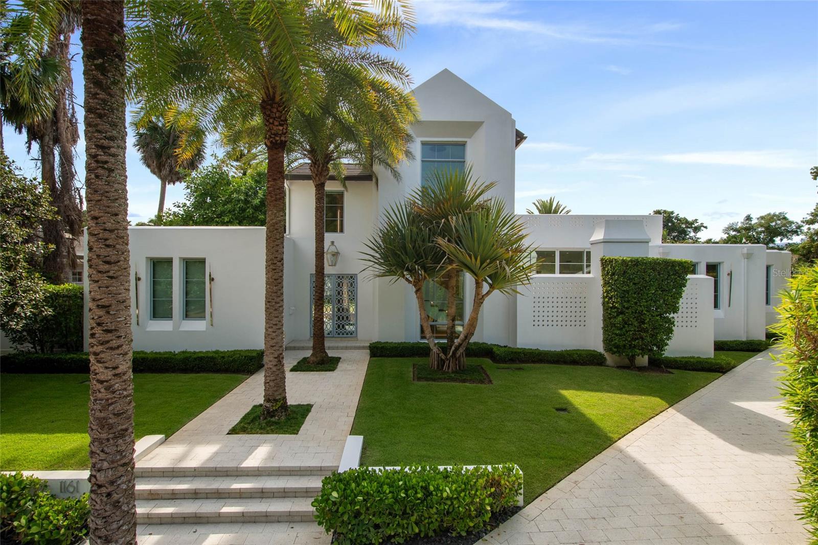 Conveniently situated near the Winter Park Country Club, this contemporary masterpiece, built by premier builder Z Properties, offers the ideal mix of style, comfort, and modern living. Completed in 2021, the residence has 4,182 square feet of thoughtfully designed living space, including four bedrooms each with a private ensuite bath and an additional powder room. A 412-square-foot casita with a wet bar and private entrance completes its functionality by providing extra flexibility, perfect for guests, extended family, workspace or workout area.
The interiors showcase timeless design with high ceilings, glass walls, and carefully curated finishes. The chef’s kitchen and butler’s pantry pair handcrafted cabinetry and stone surfaces with professional-grade appliances, flowing seamlessly into open living and dining spaces designed for both everyday living and entertaining.
Outdoors, a 65-foot lap pool anchors the private backyard retreat, complemented by a covered lanai, marine-grade summer kitchen, fireplace lounge, tree garden and lush landscaping. Solid block construction, advanced state-of-the-art home systems, and a climate-controlled two-car garage with an extended hidden driveway highlight the home’s privacy, quality, and convenience.
With a distinct European vibe under canopy trees and cobblestone streets in the desirable Valencia Terrace neighborhood, this home is just moments from Park Avenue’s boutiques, fine dining, Rollins College, the Farmers’ Market, and the Morse Museum. Zoned for top-rated Winter Park schools, it offers both luxury and practicality in one of Central Florida’s most sought-after communities.