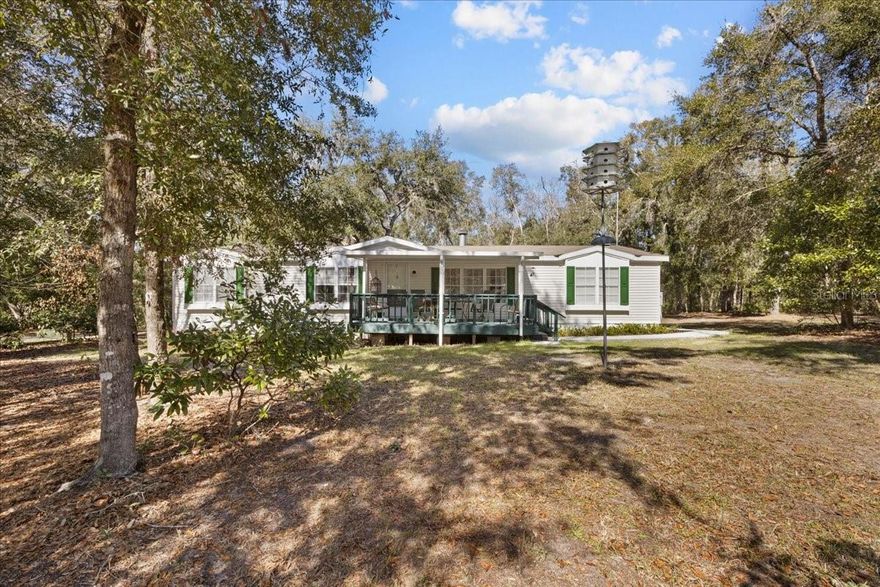 Welcome to your new little slice of heaven located in gorgeous Dixie County , just around the corner from the Suwannee River. This home is immaculate , has been updated and maintained to the highest standard. An oversized 2000 DWMH 3 bedrooms/ 2 bathrooms with a bright open floor plan. Property has a nice private driveway leading you to the oversized 2 carport large enough for 4 cars, boat, ATV , bikes etc. Front entrance offers a peaceful covered porch gazing out to the peaceful yard. Entering the home you'll see the bright open floor plan with majority new laminate wood flooring, a wood burning fireplace and a great view to the dining room and kitchen. Kitchen is nice and open with loads on cabinetry and a great breakfast nook area. Each guest bedroom in immaculate condition as well as as bathroom, with all update plumbing , faucets and fixtures throughout the whole home. Master bathroom is over sized with a spacious master bathroom with stand up shower and dual vanities. Exiting the home out the back door you have a laundry /mud room and a covered porch leading you to the massive carport. The yard is like a state park, gorgeous oak trees speckled throughout , offering multiple spigots over the total 2.34 acres , a chicken coop/feed room, storage/workshop with window unit additional utility building and pump house. Amazing fiber internet offered for ease of all wifi items. AC, hot water heater and roof all new within 5-6 years. Immaculate vinyl siding all brand new skirting as well as new lending rule of permanent backing. A short drive to town for shopping and dining. Call today for YOUR tour!