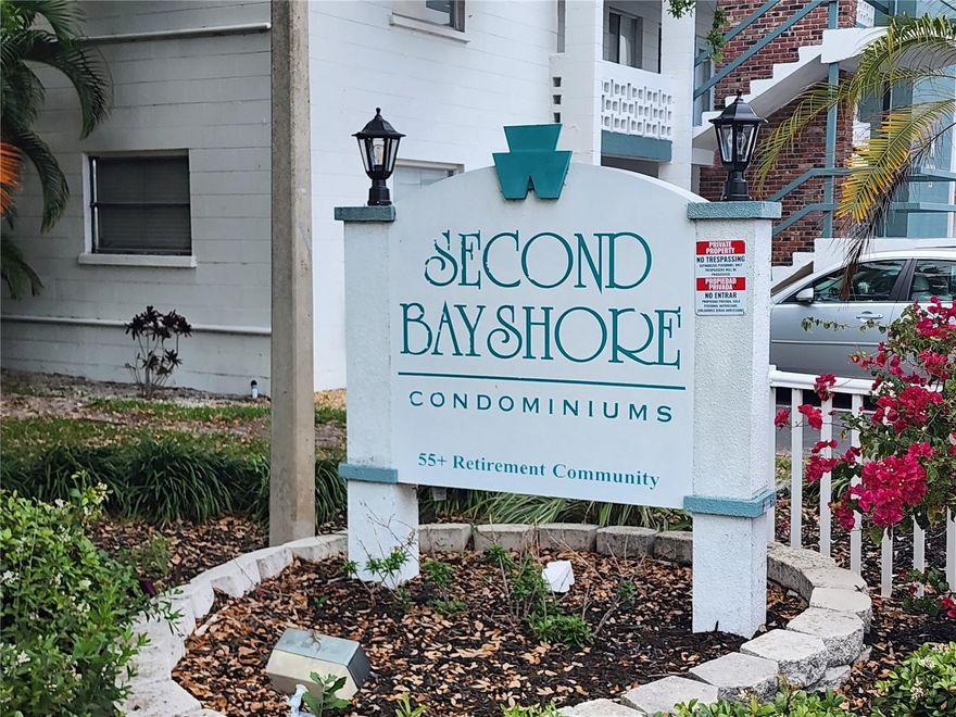 BEST VALUE IN BAYSORE SECOND CONDO – FIRST FLOOR UNIT!  FULL SIZE WASHER AND DRYER!  Stop scrolling—this is the one buyers have been waiting for. Located in a well-maintained 55+ community, this rare first-floor condo means no elevators, no hassle—just park right outside your door and walk in.  This 2-bedroom, 1-bath home is clean, comfortable, and move-in ready, featuring easy-care laminate flooring and a vinyl-enclosed lanai with peaceful, park-like views—your own quiet retreat to relax and unwind.  Hard-to-find extras include a full-size washer & dryer inside the unit and additional storage, giving you the space and convenience.  Step outside and enjoy a true Florida lifestyle with resort-style amenities: a heated pool, active clubhouse, shuffleboard courts, and beautifully maintained grounds that make this community so desirable.  Location is everything—and this one delivers. You can walk to  shopping,  and dining,  minutes to SRQ Airport, public transportation on your street (60th Ave W) , and the library. Plus, you’re a short drive to golf courses and the world-famous beaches of Anna Maria Island.  First-floor convenience        Park at your front door    Washer & dryer in unit     Low-maintenance living     Prime location.  Community rules: 55+, no pets, and must own 1 year prior to renting.  Opportunities like this don’t last—schedule your showing NOW before it’s gone.