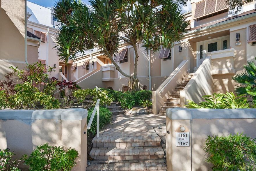 Tucked within a charming Gulf-side community of just 27 residences, this unique and rarely available townhouse on Siesta Key is in model condition and offers private access to one of the most celebrated beaches in the country. With 1,760 square feet of living space, the home features soaring two-story ceilings and abundant natural light throughout the main living areas. Head upstairs on the grand staircase to an additional bedroom plus a versatile loft space—currently used as a TV room and office—which could easily function as a third bedroom. The primary suite is conveniently located on the first floor and opens to a private enclosed sitting area.  An updated kitchen with wood and glass cabinetry, natural stone countertops, stainless steel appliances, a spacious island flows into a casual dining area and living space, all finished with engineered hardwood floors, crown molding, and a neutral color palette. Two updated full bathrooms serve both levels, and laundry is located inside on the main floor. Additional features include built-in beverage refrigeration, hurricane shutters, and dedicated closets. Enjoy the private entry and an unheard of oversized garage with space for three vehicles adding loads of additional storage and convenience. The amount of storage is like living in a single family home. The community is primarily owner-occupied, with limited rentals, and welcomes large pets. Recent association improvements include new garage doors, exterior paint, landscaping, privacy fencing and more making this community feel like new. Steps from the white sands of Siesta Key, community pool, and close to shopping and dining. This move-in ready home invites you to settle into the ease of coastal living.
