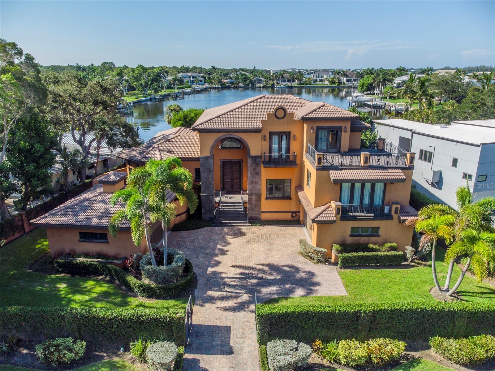 Welcome to this captivating property located in the beautiful San Remo Estates and minutes away from Siesta Key Beaches and downtown Sarasota. This house is located in an incredible location so close in proximity to great schools, restaurants, cultural destinations, and parks. This 5,160 SqFt waterfront property is nestled on a 18,416 SqFt lot behind a private gate. As you enter the front entrance, walk into the formal living area next to a private formal dining area which features a bar between the two, great for entertaining with natural light throughout the house. The spacious primary bedroom is on the main floor located off of the formal living area with two luxurious walk-in closets, featuring a serene spa-like bathroom with a beautiful tub, walk in shower, two bathrooms and dual sinks. Perfect home for entertaining and features a bar room upstairs with a video wall to entertain guests and balcony looking out to Siesta north bridge and Sarasota Bay to watch the sunset to end your day. With a seamless flow from the living area to the chef's kitchen with brand new Viking appliances, the open-concept layout is an entertainer's dream with ample space to gather. Designed to entertain, the kitchen offers a massive center island and sliding doors to the poolside terrace. Complete with pool & spa, outdoor entertaining that is complemented by an outdoor fireplace. The three en-suite bedrooms upstairs feature separate areas to give guests the utmost privacy and comfort. Two of the bedrooms featuring a private balcony for guests as well as a sitting area with plenty of room for an office or library between the two bedrooms overlooking Roberts Bay. Expansive Bay and City Views with easy access to Intercoastal Waterway, Sarasota Bay, and Gulf of Mexico. This home is a must see!
