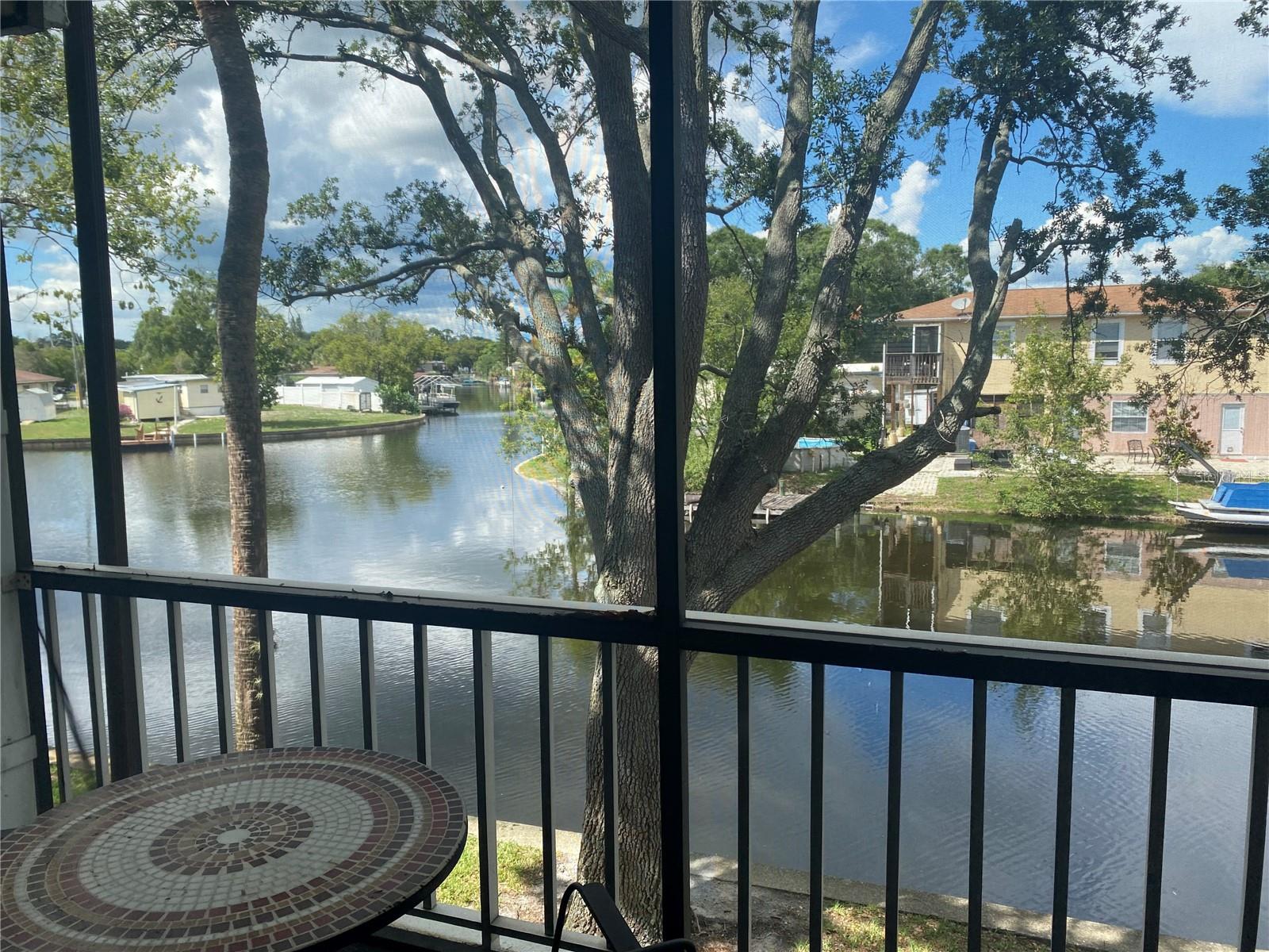 Beautiful Unit on the water. This is Florida living at its finest. This 2-bedroom, 1.5 bath 2 2-story condo is spacious and has amazing views of the canal leading out to Tampa Bay. The family room has 2 sliders leading out to the porch with an enclosed porch and balcony to sit outside and enjoy the shade of the mature oak trees for privacy. Master bedroom and 2nd bedroom upstairs with Master Bath. The master bedroom has sliders and a second covered balcony with a water view. Washer and dryer in master the master closet with built-in shelving and a walk-through to the master bath. Sit outside on any floor and watch the sunset. Community pool, tennis, handball, grills, and other amenities. Call today to schedule a showing!