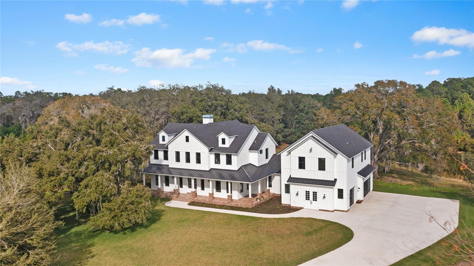 Tucked away on a sprawling 6.62-acre lot, this impressive new build and never lived in 5,271 sf Modern Farmhouse embodies the perfect fusion of tranquility and accessibility, nestled within the highly coveted Steinbrenner, Martinez, & Hammond Schools zone. Secluded at the end of a small cul-de-sac, this bespoke home boasts unique architectural touches, complemented by your own private pond and conservation vistas.
A grandeur is added to the residence with expansive wrap around brick terrace, inviting you to unwind amidst the heated saltwater pool, spa, and tranquil fountains, all enveloped by a picturesque setting shared with local wildlife.
Step inside to discover spacious rooms and a split layout adorned with premium upgrades and carefully curated designer finishes. The two-story living room, complete with beamed ceilings, brick fireplace, effortlessly flows into a chef's dream kitchen featuring top-of-the-line Italian Hallman appliances, a Big Chill refrigerator, custom cabinetry, and walk in pantry.
The first-floor primary suite offers a haven of comfort with direct pool access, custom walk-in closets, and an opulent ensuite bath boasting dual vanity and walk in glassed enclosed rainfall shower. Upstairs, a generous loft, three guest bedrooms, and two baths.
Extra space is found in the Theatre/Bonus room and office area with potential of In-law Suite, accompanied by a full bath above the oversized three-car garage. Porcelain wood plank tile floors, impact windows, Navien tankless water heaters, and three HVAC units, this home seamlessly merges sophistication with practicality.
Thoughtfully pre-inspected, this immaculate property is primed to offer the quintessential Florida lifestyle from the moment you arrive.
Marketed at the appraised value.