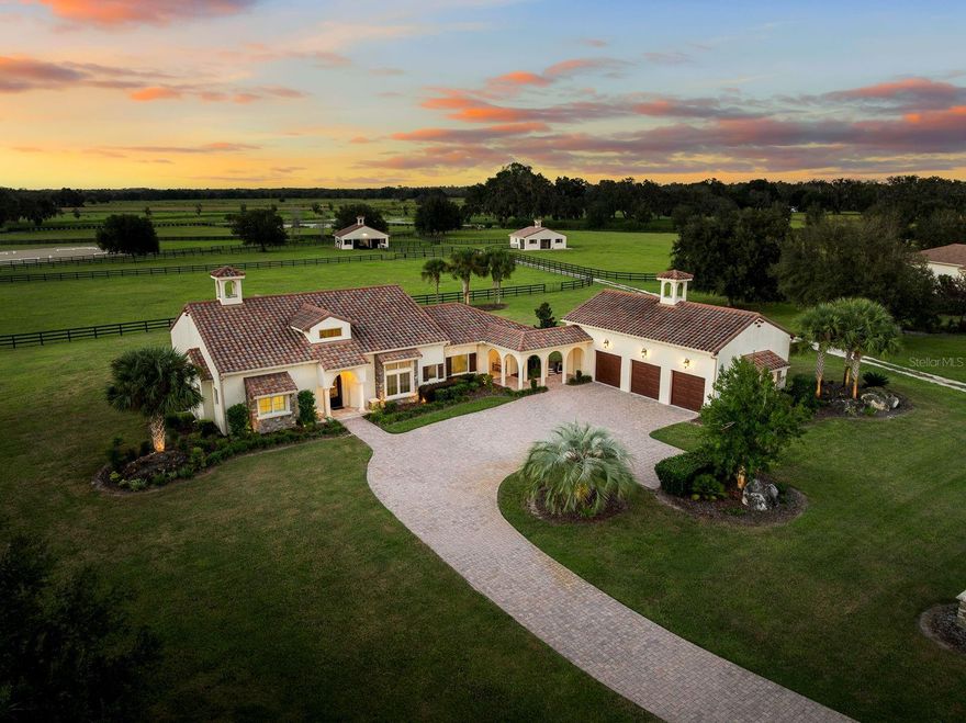 Set within the gated lakefront and equestrian enclave of Bel-Lago, this 6.32-acre equine estate embodies contemporary luxury at its finest. Completed in 2020, the custom-built residence showcases exceptional craftsmanship and materials throughout, and offered turn-key with the latest furnishings from Arhaus and Restoration Hardware. Soaring ceilings with tray detailing, travertine and hardwood flooring, and custom Dixie Workshop cabinetry throughout set a tone of refined sophistication. In the kitchen, natural light dances across the Taj Mahal quartzite countertops, and stainless-steel Viking appliances provide stylish performance. This property features 3 bedrooms + den, and 3.5 bathrooms. Each spacious bedroom is complemented with spa-inspired ensuite bathrooms, with your third guest suite offering an additional exterior private entryway, perfect for guests, multi-generational living, or farm staff. Beyond the walls, sweeping views of grand oaks and open paddocks unfold from the lanai, leading your eye to the heart of the property - a striking European style 3-stall block barn with Dutch stall doors, Equitan + SoftStall flooring, Pyranha fly spray system, spacious feed/tack rooms, stall cameras, and all the details that define a true equestrian haven. A newly laid 120’x200’ arena and lush fenced pastures make training and turnout effortless. Additional features include a whole-property (including barn) generator, and a comprehensive security system covering both the home and barn stalls for added peace of mind. From your backyard, enjoy direct access to Bel-Lago’s multi-use trail system - over 7 miles upon community completion - surrounded by 8,000+ acres of protected preservation. It’s a setting that offers peace and privacy, yet remains just minutes from Ocala’s major show venues, including the World Equestrian Center, HITS, and the Florida Horse Park. Sleek, serene, and meticulously maintained, this residence stands among Bel-Lago’s most refined - where modern design meets the timeless beauty of horse country.