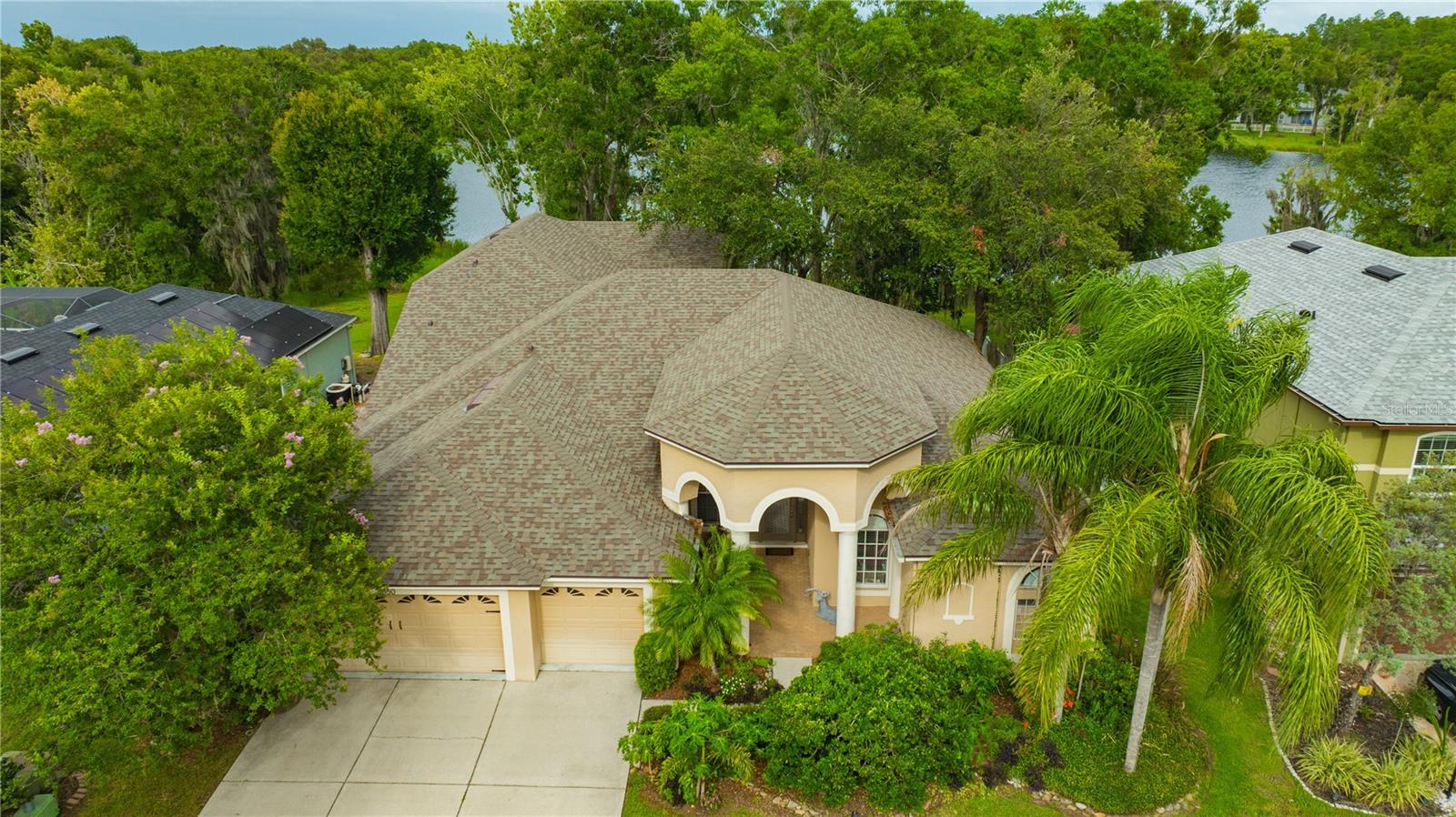 Breathtaking Lakefront Views & Exceptional Privacy! Nestled in the heart of Land O’ Lakes, this stunning 5-bedroom, 4-bathroom home offers 3,182 sq. ft. of beautifully designed living space, including a spacious upstairs bonus room (counted as 5th bedroom) with a private bath and sweeping lake views. Located directly across from a serene, spring-fed lake and bordered by a conservation area, this home offers unmatched privacy and a peaceful natural setting. From nearly every room, you’ll enjoy unobstructed views of the tranquil water and surrounding wildlife. The floor plan is thoughtfully designed with soaring ceilings, architectural details such as niches, columns, and rounded corners, and generously sized rooms throughout. The gourmet kitchen features granite countertops, stainless steel appliances, solid wood cabinetry, a custom refrigerator with wood panels matching the cabinets, reverse osmosis water system, and a large walk-in pantry. The expansive primary suite boasts two walk-in closets, elegant entry, and stunning lake views – imagine waking up to sunrises over the water! Flexible indoor laundry options with hookups in both the mudroom and the converted craft/multi-purpose room. Separate office. Bonus room upstairs with private bath, walk-in closet, and panoramic views – ideal as a guest suite, office, or media room, or fifth bedroom. Abundant storage and ample closet space throughout. 3-car garage for even more storage. This stunning home features a new roof (2022), water heater (2023), and main heat pump (2025). Low HOA and no CDD fees.
Outdoor Living at Its Finest:
• East-facing backyard offers a cool, shaded retreat, ideal for outdoor entertaining
• Mature oak trees, a gentle breeze off the lake, and natural landscaping invite birds and wildlife right to your doorstep
• Natural boat launch for canoes, kayaks, and boats with trolling motors
• Strategically placed trees frame the view while enhancing privacy and serenity
Community Perks:
• Secure, gated neighborhood with two private entrances
• Walking trails, basketball court, three parks, a playground, and sidewalks
• Easy access to Hwy 41 and Hwy 54 via nearby Oakstead cut-through
This home effortlessly combines the feeling of a lakeside getaway with the functionality, luxury, and upgrades of a year-round residence. Whether you’re entertaining, relaxing, or exploring the outdoors, this is a rare opportunity to own a truly special property. Don’t miss your chance to make it yours!