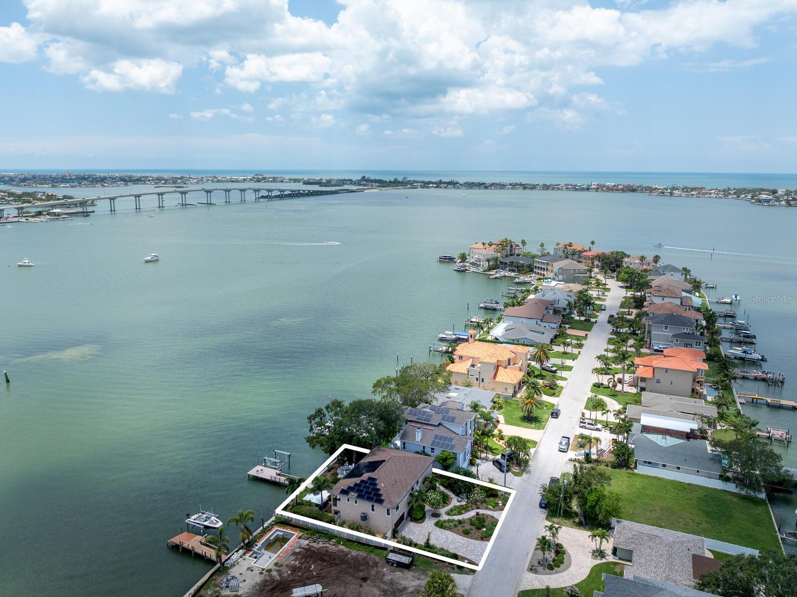 NEW 2019 CUSTOM HOME BUILT TO CURRENT STORM CODES...living level of home had no issues with recent storms...this exquisite custom-built home offers the best of Belleair waterfront living with breathtaking southern-facing open water views of the Intracoastal Waterway and the Belleair Causeway. Designed for elevated living and efficiency, this residence blends waterfront luxury with smart upgrades and unmatched views. A residential elevator provides easy access to the main level, where sunlight fills the open-concept living space featuring 9-foot ceilings, crown molding, porcelain tile and motorized window treatments throughout. HIGH-IMPACT WINDOWS AND DOORS ensure peace of mind and energy efficiency, while whole-home NAD Blue Sound and KEF audio systems deliver immersive sound indoors and out. THIS HOME IS POWERED BY SOLAR PANELS AND HAS 3 POWER WALLS FOR WHOLE HOME BATTERY BACKUP. The chef's kitchen is a showstopper with Blue Bahia granite countertops and backsplash, an oversized center island, custom cabinetry with built-ins and rollouts, and top-of-the-line appliances including a KitchenAid counter-depth refrigerator, Electrolux five-burner cooktop, built-in Frigidaire Professional convection oven and microwave, and a 120-bottle wine cooler. A motorized electric trash chute also adds convenience to this space. The expansive 63-foot Trex balcony deck is ideal for entertaining or relaxing with its built-in Red Lion five-burner gas grill and motorized SunSetter awnings. King-sized primary suite offers sweeping water views, a large custom walk-in closet and a luxurious spa-style bath with soaking tub, oversized walk-in shower, double vanities, and a private commode room with automated Toto. The second spacious bedroom features a custom closet with abundant storage, an upscale en-suite bath featuring a separate soaking tub, walk-in shower, double vanities and a private commode room with Toto, providing comfort and privacy for guests. The well-appointed study is ideal as a home office or potential 3rd bedroom. Full-size laundry room is conveniently off the main hall with custom granite and cabinetry. Downstairs, you’ll find two flexible bonus rooms with sliding doors to the backyard. This space is ideal for entertaining, game room, media room, gym or additional home office. The extra deep 18-by-33-foot two-stall garage includes epoxy floors (2025), ample storage, and can easily accommodate a golf cart or recreational gear. Outside you’ll find new lush 2025 Florida native landscaping and expansive patios. Your private composite dock, built in 2019 with all new wrapped pilings and seawall, includes a remote-controlled 13,000-pound boat lift, dock lighting and a Tempest weather station. Additional upgrades include a commercial water heater (2025), water softener, electronic HVAC filter system, LED lighting and more. Located in the quaint Town of Belleair with its own police department, recreation center, town hall and over 15 greenspace and dog friendly parks. Close to Gulf beaches, excellent medical facilities, banking, shopping and dining. A golfer's paradise with Belleair Country Club and Pelican Golf Club. TPA 40 minutes & PIE 30 minutes. This is waterfront living at its finest, blending high-end finishes, smart technology and Florida charm, all with incredible open water views, just bring your boat! See the feature sheet attached with all the bells and whistles. Floor plan photos 62 and 63. Vimeo: https://vimeo.com/1097082065
