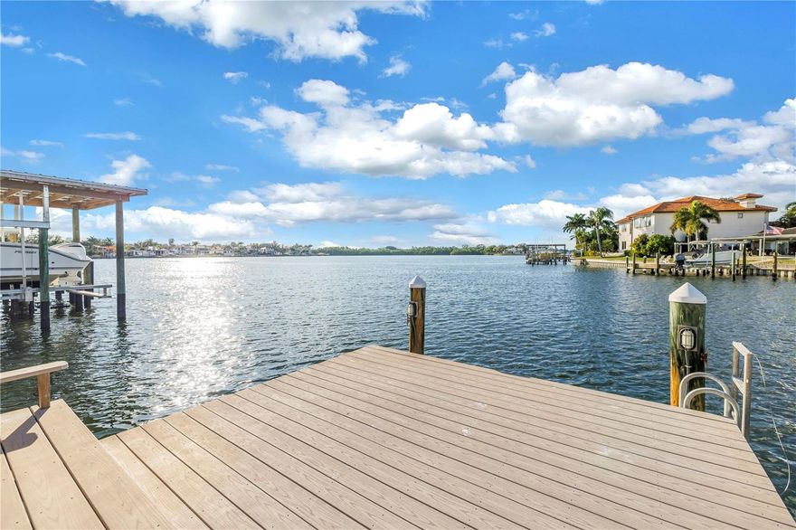 This fully renovated (2023), waterfront home offers an exceptional blend of luxury, functionality, and modern design. Featuring four bedrooms, two and a half bathrooms, and two flex rooms, the home showcases a split floor plan, enhanced by recessed lighting, new tile flooring throughout, abundant storage, newer impact windows and doors, and elegant plantation shutters. The chef’s kitchen is thoughtfully designed with KitchenAid stainless steel appliances, including a double oven and warming drawer, French-door refrigerator, walk-in pantry, quartz countertops, and a pot filler. A wet bar adds to the home’s entertaining appeal, complete with an additional beverage refrigerator and freezer. The living area is anchored by a striking electric stone fireplace and framed by impact sliding doors that open to the covered rear patio, offering beautiful bayou views. The primary suite is a true retreat also enjoying waterfront views and direct patio access through impact sliding doors. The expansive owner’s walk-in closet and dressing room features custom cabinetry and a built-in island/dresser. The spa-inspired primary bathroom includes custom cabinetry, dual sinks with quartz countertops, and a large, tiled shower with dual shower heads and a rain shower head. A guest bedroom also opens directly to the rear patio, further enhancing the home’s connection to the outdoors. Two other spacious bedrooms share a stunning hall bathroom with a tub/shower combination. Exterior features are equally impressive, with protected open-water frontage, a private dock, a covered patio with tongue-and-groove ceiling, and pavered front and rear outdoor spaces. The custom built salt water lap style pool and spa offers relaxation with a spa completes the resort-style setting. A large open patio space make outdoor entertaining easy. Additional highlights include two outbuildings (a large storage shed and a doll house feel shed that is air conditioned, which could be used as an office,  a whole-house generator, a central vacuum system, and an oversized garage with an impact-rated garage door. The well-appointed laundry room offers custom cabinetry, quartz countertops, and a soaking sink. Major system upgrades provide peace of mind, including fully redone electrical and plumbing, newer HVAC, a newer tankless water heater providing instant whole-house hot water, a newer tile roof (2024), and newer front doors, a water softener—making this exceptional waterfront property truly move-in ready. Easy access to downtown by boat or car. Enjoy Florida's lifestyle in this luxury home!