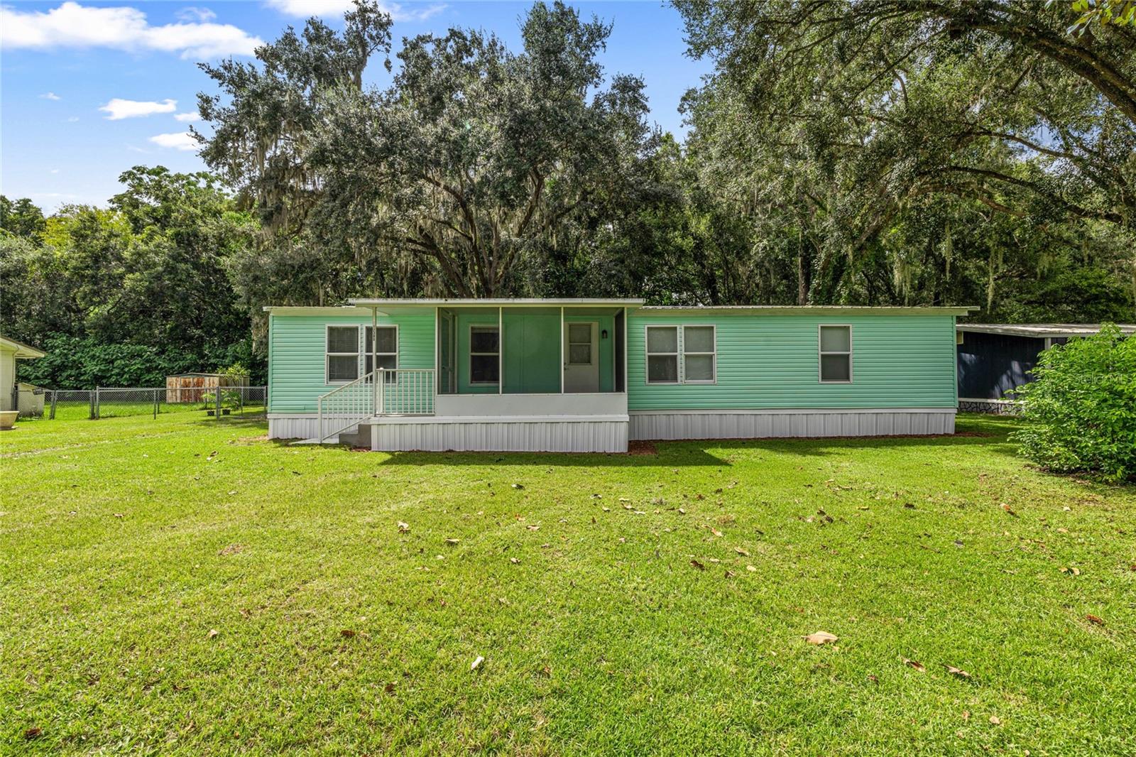 Discover the charm of this inviting 3-bedroom, 2-bathroom home situated on a spacious .28-acre lot. Perfectly designed for families or anyone seeking convenience, the property features a carport that comfortably accommodates two vehicles, along with an 8' x 18' shed for additional storage needs. Step inside to find beautifully updated bathrooms and a modern kitchen, alongside new carpets and flooring that add a fresh touch to every room. Enjoy the convenience of being near shopping centers, schools making daily errands a breeze. For outdoor enthusiasts, Lake Weir is just a short stroll away, along with the popular Gator Joe's restaurant for casual dining. Additionally, a quick drive takes you to The Villages area, offering a variety of shopping and restaurant options. This home is truly move-in ready, waiting for you to make it your own!
