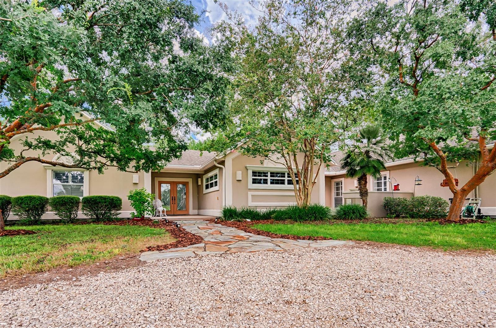 One or more photo(s) has been virtually staged. Welcome to Brandon Estates – a serene 5.48-acres in Alachua! This spacious 4-bedroom, 3-bathroom home offers 2,920 sq ft of living space. Step through the landscaped entry and glass French doors into a vaulted foyer. Just off the entry, a private bedroom with en-suite bath is ideal for guests or a home office. To the right, a large formal dining room opens via pocketing sliding doors to a 14' x 38' screened back porch—perfect for entertaining or relaxing with a view of your yard. The living room features a wood burning fireplace and floor to ceiling windows overlooking your front deck. The kitchen’s large eat-in area, has sliders to the deck. The owner's bedroom has vaulted ceilings, two walk-in closets, and a bath with jacuzzi tub and a spacious walk-in shower. Two additional bedrooms share a hall bath. A detached 12' x 30' outbuilding with overhead door includes a separate finished room with built-in benches, racks, with air conditioning—ideal for hobbies, workshop or flex space. The fully fenced property is equipped with an invisible fence system, an oversized 2-car garage with EV charging station, concrete driveway, with pebbled circular drive. There is a 15KW generator with transfer switch and owned propane tank. Near Hal Brady Recreation Complex, Legacy Park, San Felasco Hammock State Park, City of Alachua Downtown Historic District. Easy drive to Gainesville, UF, Shands and HCA Florida.