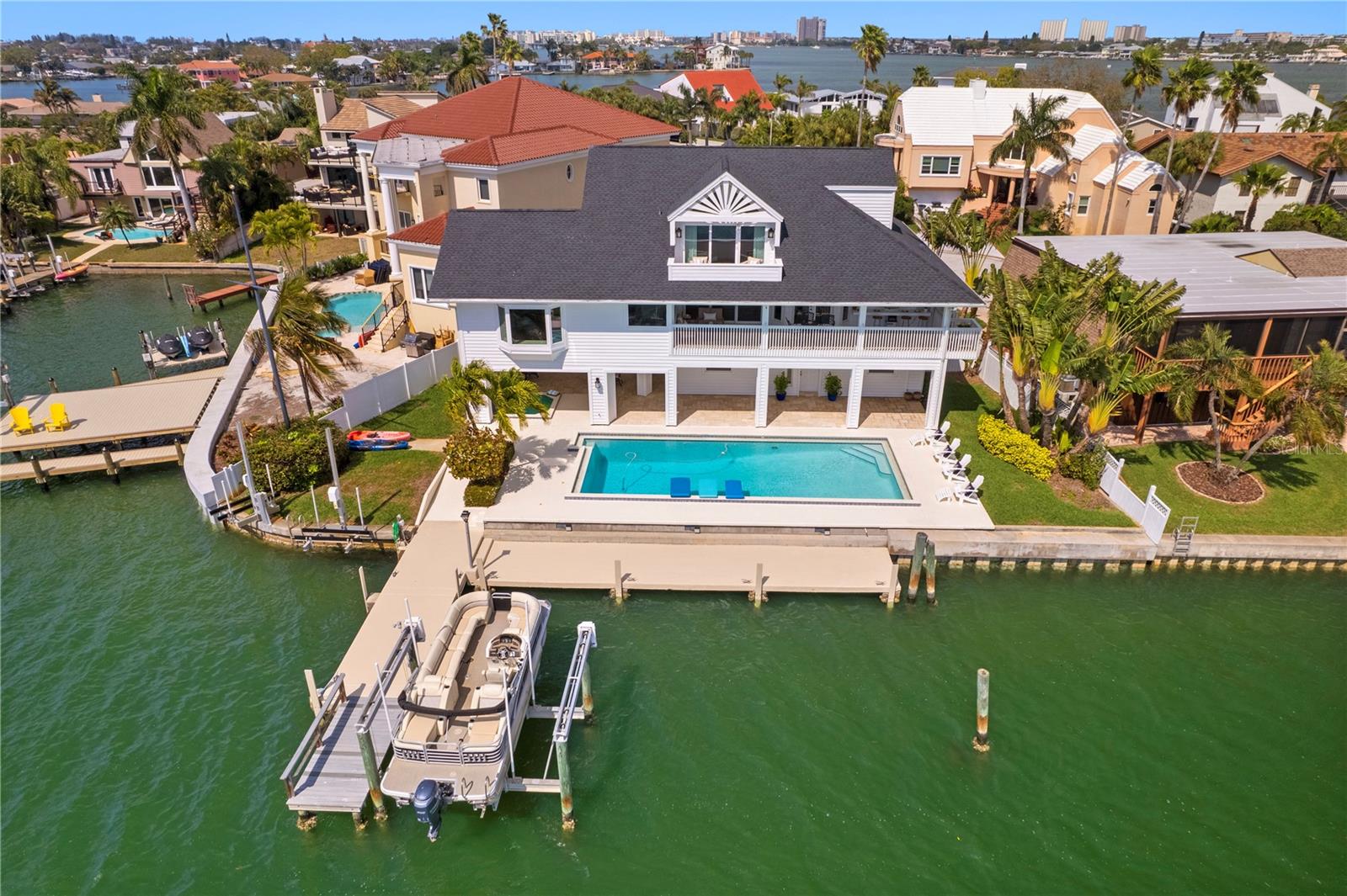 Under contract-accepting backup offers. Live like you're on vacation everyday in this amazing home that boasts 113 ft of water frontage on Boca Ciega Bay and over 6600 sq ft under roof! So many thoughtful details resonating throughout, you'll love them all! The interior spaces are generous, the outdoor spaces are tremendous and the surrounding area creates a perfect place for Fun with Family and Friends. If you are looking for that unique coastal living experience, this home is a must see. Pride of ownership is apparent the moment you walk in. The interior space is light, bright, architecturally unique and inviting. The outdoor space is truly exceptional; boasting a heated lap pool, covered entertaining space and spa, expansive concrete dock, full electric/water, a 16K lb boat lift and two jet ski lifts create the ultimate outdoor living experience. Are you are a "cook your catch" off of the dock fishing enthusiast or an avid boater seeking easy access and no bridges to the Gulf of Mexico, this home has it all! Wake each morning to our fabulous sunrises and enjoy award winning sunsets without leaving your home. Easy access to vibrant Downtown St Petersburg to enjoy trendy restaurants, visit acclaimed museums or to catch a Rays or Rowdies game. Quick drive to Tampa Int'l or St Pete/Clearwater Airports, makes business or casual travel a breeze. Whether you choose to walk, bike or take the golf cart, there are so many fun things to do!