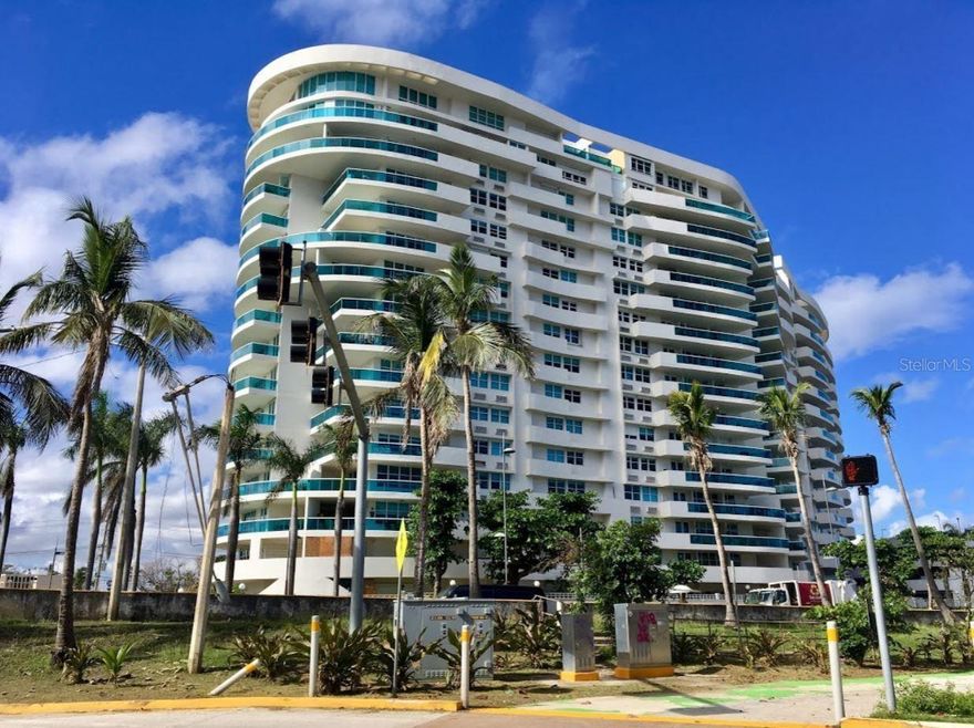 Condo unit #901 at Millennium offers 1,920 square feet of functional living space on the 9th floor, oriented northwest with expansive views of San Juan Bay and the Atlantic Ocean. The residence features an open layout integrating kitchen, living, and dining areas that extend to a wraparound balcony. It includes two bedrooms plus a primary suite with a walk-in closet and a private bath. Additional features include a laundry room with appliances, four deeded parking spaces, a private storage unit, and building amenities such as 24/7 security and valet services. The property is available for LEASE & SALE.