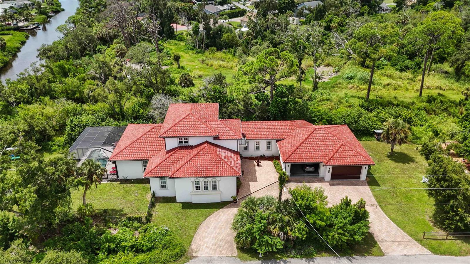 Experience the ultimate Florida lifestyle in this exceptional 4-bedroom, 4.5-bathroom waterfront estate on scenic Alligator Creek with direct access to a private beach by kayak. Built for both luxury and function, this home offers a pool & spa, 8-car garage (4 tandem or space for boat storage), and a boat dock & new ramp (2024).
Step inside to soaring 12-foot ceilings, hurricane-rated front door & windows, and a flexible floor plan with all bedrooms featuring walk-in closets. The primary suite is located on the first floor with an updated spa-style bath. The home also features an in-law suite with a private bath, walk-in closet, living area, and kitchenette. Additional bedroom highlights include one bedroom with a private bath and another bedroom with a balcony.
The chef’s kitchen is complemented by a wine refrigerator (conveys), and an expansive dining and entertaining space. Recent upgrades include a new water heater (2025), new pavers (2024), and a full-home generator (gas or propane). Comfort is ensured with 4 AC zones, a water softener, water filtration system, and security system with cameras and TVs (convey).
Enjoy outdoor living including an outdoor kitchen with a new refrigerator (2025), multiple fruit trees, a gazebo & garden with solar lights and a fire pit, a dog run, and a covered patio overlooking the water. No HOA restrictions.This property is a rare combination of privacy, luxury, and boating access—perfect for those who want it all.