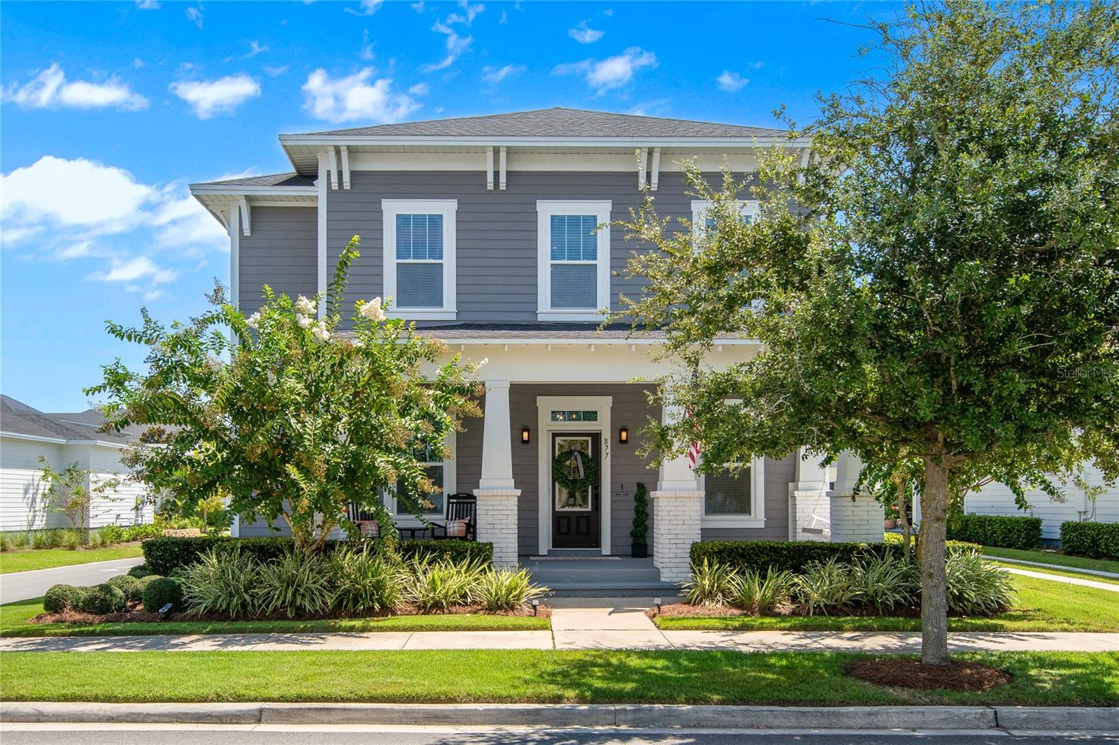 Modern Craftsman Charmer in Oakland Park – Corner Lot, No Rear Neighbors, and Steps from the West Orange Trail!
Welcome to 877 Tilden Oaks Trail, a beautifully designed David Weekley Modern Craftsman home in the heart of Oakland Park—one of Winter Garden’s most sought-after communities. Featuring 5 bedrooms, 4 bathrooms, 3,084 sq. ft., and stunning curb appeal, this move-in ready home offers timeless character, incredible location, and thoughtful upgrades throughout. Situated on a private corner lot with no rear neighbors, this home delivers both space and serenity. From the inviting rocking-chair front porch to the charming detached rear-entry garage with a Tesla Level 2 EV charger, every detail has been carefully curated.
Inside, you'll find wide-plank white oak laminate flooring, a dedicated home office, and an open-concept layout that flows beautifully for entertaining. The chef’s kitchen is a showstopper, boasting quartz countertops, a farmhouse sink, built-in wall oven and microwave, custom 42" solid wood cabinetry, and a gorgeous herringbone tile backsplash—all centered around a large island ideal for gatherings. The first-floor primary suite is a true retreat with a spa-inspired bathroom featuring wood-look ceramic tile, dual vanities, a soaking tub, a walk-in shower, and an oversized custom walk-in closet. The spacious family room opens up to a screened-in rear patio through elegant French doors, providing indoor-outdoor living year-round. Upstairs, you’ll find a large loft and three additional bedrooms, perfect for family, guests, or flex space. This layout offers versatility for today's modern lifestyle.
Live the Florida Lifestyle in Oakland Park, a masterfully planned traditional neighborhood design (TND) community with mature oaks, lakes, parks, and preserved natural beauty that captures the essence of “Old Florida.” Amenities include:
* Two resort-style pools
* Walking trails and green spaces
* Direct access to the West Orange Trail (just 2 blocks away!)
* Golf cart access throughout and into the Historic Downtown Winter Garden district
Located in the golf cart district, you’re just minutes (or a short bike/golf cart ride) from:
* Downtown Winter Garden, Plant Street Market, Crooked Can Brewery, boutique shops, weekly farmers market, and local eateries
* Top-rated public and private schools
* Easy access to major highways including SR 429 and the Turnpike
Why wait to build new? Inventory is tight and new construction comes with long wait times and rising costs. This home is move-in ready, meticulously maintained, and packed with upgrades—making it an ideal opportunity for buyers who want it all, now. Don’t miss your chance to own this one-of-a-kind home in one of Central Florida’s most beloved communities. Schedule your private tour today!