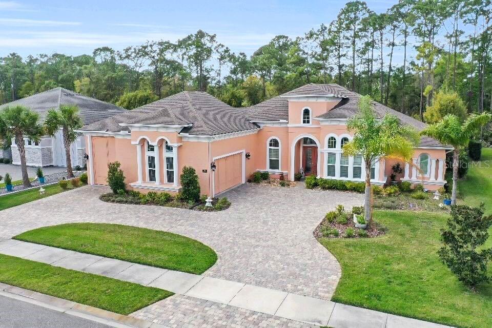 Step into a world of refined luxury with this exquisite 5-bedroom, 4½-bathroom residence, masterfully crafted in 2019 and spanning an impressive 3,237 square feet of sophisticated living space. This architectural gem seamlessly blends timeless charm with modern convenience, offering an unparalleled lifestyle for the discerning homeowner. The heart of the home is a gourmet kitchen that radiates opulence, featuring lustrous granite countertops, a grand island with a sink, and a bespoke coffee bar that transforms morning rituals into an art form. Bar seating and a generous pantry enhance functionality, while recessed lighting casts a warm glow over the 24x24-inch porcelain tile flooring that flows gracefully throughout the residence. Crown molding adorns every room, adding a touch of regal character, complemented by 8' interior doors and 5¼'' baseboards that elevate the aesthetic to new heights.
The living room, a masterpiece of design, boasts a soaring 13' ceiling with tray accents, surround sound, and remote-controlled blinds that frame a stunning 4-panel pocket slider with impact glass. This opens to an outdoor living sanctuary where sophistication meets nature: an outdoor kitchen, paver fire pit, ceiling fans, recessed lighting, and outdoor speakers create an entertainer's paradise, enclosed by a sleek black wrought iron fence and accented with gutters for seamless style.
Retreat to the primary suite, a haven of tranquility featuring expansive his-and-her walk-in closets and a double tray ceiling that adds depth and grandeur. The en-suite master bath is a spa-inspired escape, complete with dual sinks, a luxurious garden tub, and a separate shower stall designed for indulgence. An in-law suite, equally refined with surround sound and meticulous detailing, offers versatility and comfort for guests or extended family.
Beyond the interiors, this home includes an oversized 2-car garage with pull-down stairs leading to attic storage, seamlessly connected to an RV garage perfect for the modern adventurer or collector seeking both luxury and practicality. From the tray-ceilinged entryway to the circular paver driveway and block-and-stucco exterior adorned with decorative corbels, every detail of this home exudes distinction. Modern luxuries like remote-controlled blinds in the kitchen nook and living room, paired with timeless touches like crown molding, make this residence a rare find, a harmonious blend of innovation and grace, ready to welcome you home.