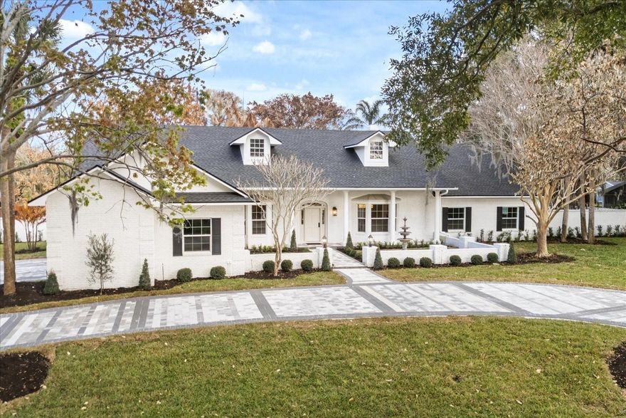 Villa Casablanca | Luxury Windermere Estate on 1-Acre. Some homes are built. Villa Casablanca was transformed. 
Set on a rare private acre within one of Windermere’s most privately held enclaves— this white-painted brick estate makes an immediate architectural statement. A circular motor court, tiered fountain, and mature canopy trees establish presence before you ever step inside.
What unfolds within is architectural theater. Vaulted ceilings rise to a dramatic 14-foot peak as skylights and expansive double-pane windows flood the interiors with natural light. A sculptural chandelier crowns the volume, while a full-height stone fireplace ascends as the focal point. French glass doors frame panoramic views of the private rear oasis — pool, pergola, and mature canopy beyond — creating a seamless connection between interior grandeur and outdoor serenity. Bay windows overlook the fountain and motor court, creating a balanced dialogue between arrival and retreat. 
The chef’s kitchen commands attention. A grand Taj Mahal quartzite island defines the center. White oak cabinetry spans floor to ceiling. The Thor range and sculpted hood rise against a full-height stone backdrop. pot filler., Viking refrigerator. Glass pendants hover overhead -- Every finish carries presence. The scullery unfolds unexpected, elevated, and unforgettable — Deep olive custom cabinetry, textured tile, LED-lit shelving, beverage refrigeration, and layered storage make it as functional as it is striking.
A split plan introduces the primary suite — vaulted, private, composed. A sculptural chandelier anchors the ceiling while tailored wall moldings define the room. Dual concealed walk-in closets preserve symmetry. The primary bath is a statement of design: matte stone soaking tub beneath clerestory light, full-height stone extending into a curbless marble shower, dual tailored vanities with brushed brass accents, and patterned marble floor grounding the space in immersive opulence. An adjoining vaulted extension captures pool views and opens to the lanai.
The powder room shifts tone — charcoal paneled walls, sculptural marble sink, polished brass fittings, arched mirror, and bold tile creating a rich, moody presence.
A formal office behind glass French doors offers focused productivity and polished presentation. An arched corridor leads to the secondary wing where three additional bedrooms offer privacy and versatility. One suite provides direct exterior access, functioning as a cabana retreat with its own en suite bath — ideal for guests or seamless indoor-outdoor living. 
Outdoors, the property transforms into a private compound. A covered veranda spans the rear with classical columns and herringbone flooring. The fully equipped summer kitchen, custom wood pergola lounge, expansive lawn, fresh sod, rear gate access, and lush landscaping offer scale impossible to replicate in today’s market.
Villa Casablanca is not comparable to new construction. It is rarer. Extensively renovated inside out with a long list of brand new finishes - Roof, HVAC, Double pane windows, plumbing, pool refinish, smooth drywall level 5 finish and much more. Schedule your showing today.