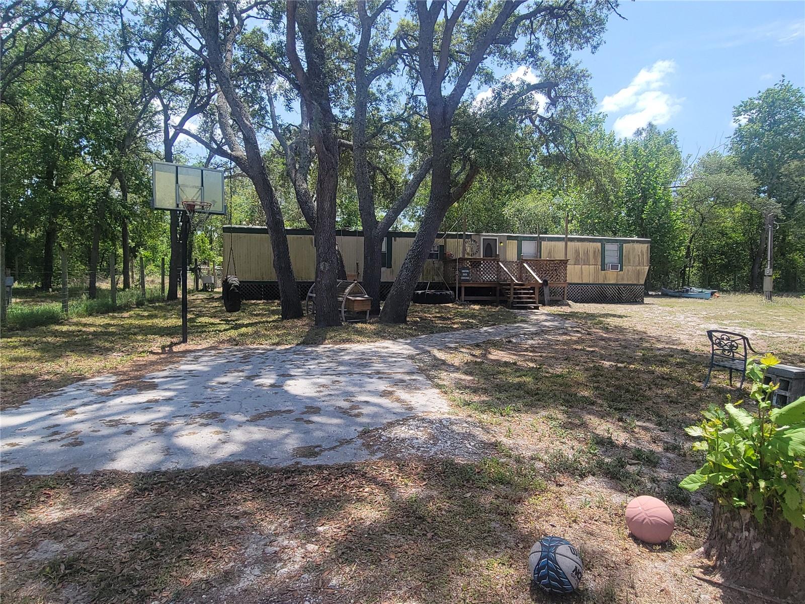 FIXER UPPER, ESCAPE HOUSE, or INVESTMENT!! This 1983 three-bedroom, two-bath manufactured home is livable and functional. It sits on .86 acres, with an adjacent .50-acre lot also for sale at 5467 S. Frost Pt MLS#W7874882. Bundle them and make an offer.
Features include a 2024 Whirlpool stove/rangehood, a 2024 Maytag refrigerator with water dispenser and ice maker, new toilets, wall A/C/heat unit, working well and septic system (pumped on 7/7/23) with new riser cover. The property includes a chicken coop, a 40’ shipping container, a log two-story treehouse, swings, two sheds, and a small two-stall barn. Both properties are sturdily fenced.
Property is in an area surrounded by Withlacoochee State Forest where one can hike, trail blaze, hunt, horseback, camp, bike, and ride ATV or dirt bike. Just east of SR 589/Suncoast Expressway in Florida’s Nature Coast.