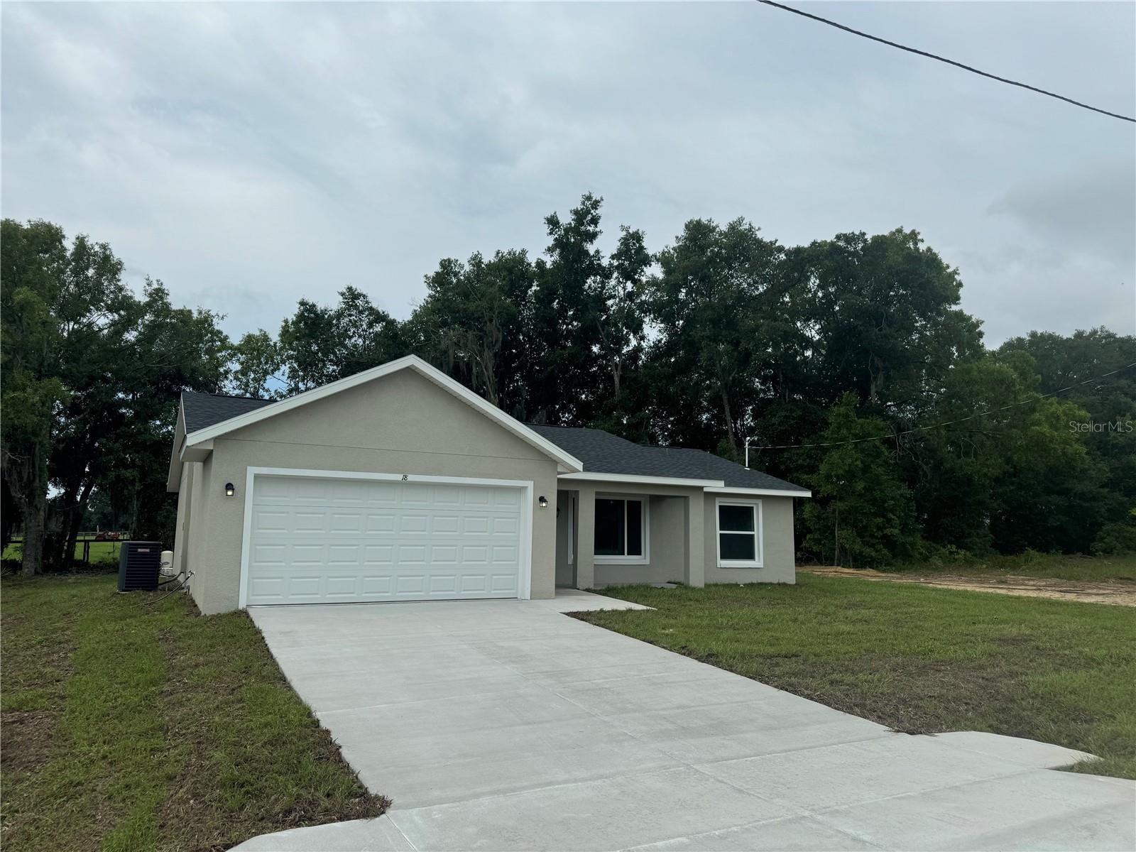 This lovely 3 bedroom, 2 full bath, 2 car garage home in Ocklawaha offers the perfect blend of modern and privacy! As you step into this home you will be welcomed with vaulted ceilings and plenty of natural sunlight. The interior boasts with brown LVP flooring and granite countertops in the kitchen and bathrooms! The open floor plan seamlessly flows into the living room, adorned with stunning bright white shaker cabinets and a kitchen space overlooking the backyard. The kitchen ,featuring stainless steel appliances, a glass stove top, dishwasher, microwave, and a side by side water and ice dispenser all complimented by gray, black, and white granite countertops. Privacy is guaranteed with this split plan layout, especially in the master bedroom with its oversized walk-in closet and a master bathroom equipped with a stand-up shower, his & her sinks, and matching white shaker cabinets. If you venture to the backyard it also offers privacy with no neighbors behind you. To top it off this home offers its own private well and septic lowering your costs on utilities. Don't wait, come tour your new home today!