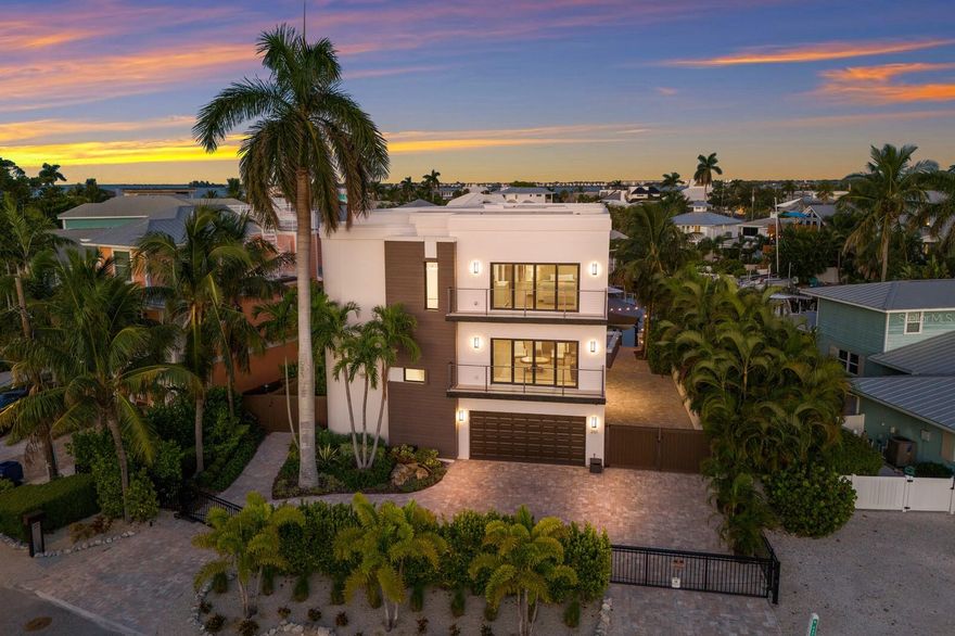 Discover an unparalleled living experience in this architecturally stunning island residence, meticulously renovated in 2022 by Richard Haas of Haas Modern Architecture & Design with bespoke floating stairs seamlessly blending cutting-edge design with luxurious amenities, all set against the backdrop of serene harbor views and near pristine beaches. Modern comprehensive renovation infrastructure: Taken down to the blocks then completed with new electrical and plumbing systems, a robust beam and poured cement, Level 5 finish walls and a high-grade GAF underlayment roof, ensuring durability and peace of mind. This unique location is one of only two homes offering boatable water access and beach views, with the pristine shoreline just two blocks away. Direct harbor access includes a new 2024-installed dock with a Golden boat lift supporting up to 16,000 pounds and 35-foot boats. The 2022 harbor dredging is ideal for maritime adventures. The kitchen boasts sleek quartz countertops, a JennAir six-burner gas stove, top-tier JennAir appliances, and elegant ceiling-reaching cabinets with a walk-in pantry ideal for culinary enthusiasts. Integrated remote-controlled blinds, custom Lyteworks ceiling fans, stunning tile throughout the home and an elevator ensure convenience and comfort at every turn. Plenty of space to add a custom pool, generator-ready setup, 250-gallon buried gas tank, two 21 SEER air-conditioning units for the upper floors and a split air-conditioning unit for the ground level, saltwater softener and two instant water heaters. Luxurious baths to indulge in spa-like settings featuring rain showers, quartz finishes, all Toto toilets, and in the primary bath a smart Toto washlet plus toilet in a private water closet, boasting dual sinks, multiple showerheads and an expansive walk-in custom-built closet. The views are memorable as you wake up, spend your day and go to rest. This property stands as a unique sanctuary, combining design, premium amenities and an enviable location for the discerning homeowner. With a certification of completion date of 2022 meeting the new codes of 2021, beneficial for insurance, this residence is more than just a home, it’s a testament to refined living, offering a harmonious blend of luxury, innovation, an extraordinary island sanctuary designed for those who demand the best.
