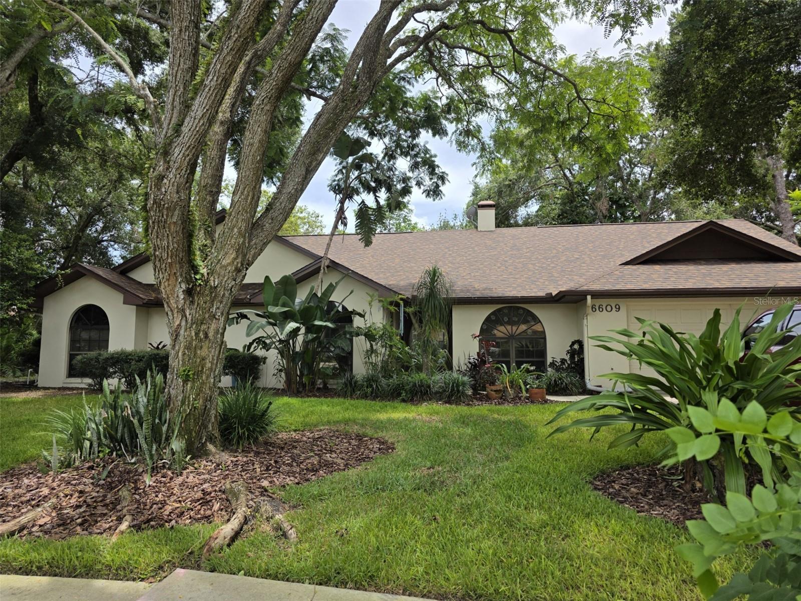 Stop the car, you do not want to miss this opportunity. This lovely four bedroom, three baths and two car garage home is waiting for you and there is no HOA nor CDD. Walk through the double doors and be amazed by the beauty of the huge family room (formal living room) with a brick built-in fireplace and cabinetry and built-in surround sound. Skylights in the Family Room, Kitchen and Master suite add another dimension of natural lighting for artwork, plants, and a little natural vitamin D. In this split level home you'll find a formal dining room (or excellent place for a pool table), a huge kitchen with an island, a second dining area, inside laundry room with washer and dryer and a ensuite bedroom/bathroom area that leads to the outside patio. The bedroom/bath combo could serve as an area for guest or as an in-law suite. This entire side of the of the home is great for entertaining guest and/or family gatherings. You can then, pass through the family room and the french door to reach an area for just relaxing, bedding or a quiet get-away from it all - two bedrooms, a full bathroom, multiple storage closets and the master suite. This home has amazing lighting throughout. Enter the double doors to escape to the master suite with a ensuite bathroom with dual sinks, water closet, walk-in shower and a huge walk-in closet. Both the bedroom and bathroom have exit doors leading the the extended exterior patio. The beauty within this home will definitely captivate you. The home also has a new roof (6/2025). It is located close to USF, various restaurants, shopping, the interstate for quick access to downtown Tampa, Ybor City, Armature Works, the airport or for heading east to Orlando or north to Ocala. Don't miss the opportunity to live and shop and such an amazing location. (Cameras do not convey and there are two cats on the premise - please do not let them out)