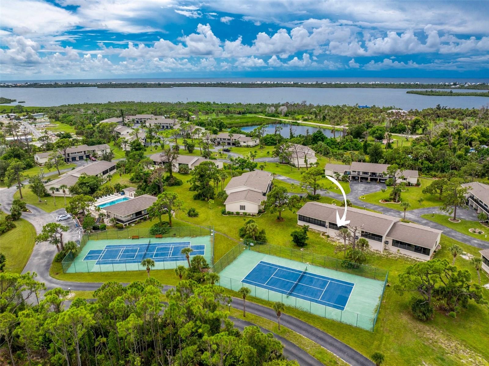 From Poolside to Paradise – Welcome to Forest Park! This turnkey furnished light and bright 2 bedroom, 2 bathroom condo makes Florida living simple and fun. Step inside to an inviting open layout with sliding doors that open to a tiled and screened balcony overlooking the tennis and pickleball courts. The main living areas feature easy-care tile floors and the bedrooms are comfortably carpeted. The kitchen is designed with plenty of wood cabinets, ample counter space, and a raised breakfast bar that connects seamlessly to the living area. The ensuite primary bedroom has sliding doors for lanai access and dual closets, while the bath offers a walk-in shower. Guests will enjoy a spacious bedroom with a reach-in closet and a full bath with a solid surface vanity and tiled tub and shower combination. Downstairs, you will find an under-building garage and a bonus private storage room perfect for all your beach gear and golf clubs. The community offers a heated pool, clubhouse, tennis, pickleball, shuffleboard, and boat parking. Low condo fees cover flood insurance, building exterior, roof, pest control, landscaping, cable, water, and sewer so you can spend more time enjoying the Florida lifestyle. Located close to beaches, golf courses, marinas, restaurants, and shopping, 4260 Placida Road is a wonderful opportunity to make Forest Park your Florida home. Schedule your showing today.