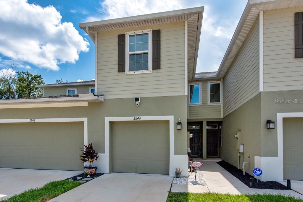 Tucked away in the heart of Holiday, this beautifully upgraded 3-bedroom, 2.5-bath home offers both comfort and convenience in a golf cart–friendly community just minutes from everyday essentials. With no flood zone worries and sitting 12 feet above sea level, this property brings peace of mind along with modern living. The 1-car attached garage features a spacious layout and an epoxy-finished floor. Step inside and be welcomed by a smart, split-bedroom layout designed for privacy and functionality. The spacious eat-in kitchen is perfect for the home chef, featuring granite counters, a breakfast bar, a pantry, and sleek new appliances. The open-concept layout flows into the main living area—ideal for entertaining or quiet evenings at home. The oversized owner’s suite features a walk-in closet, double vanity, and walk-in shower—your personal retreat after a long day. You'll also love the convenience of the second-floor laundry room—no more hauling baskets up and down stairs! Head outdoors to your private sanctuary: a screened-in lanai opens to a fenced-in extended patio with low-maintenance Astro Turf, perfect for grilling, lounging, and letting your pets roam safely. Best of all, the private backyard backs to a serene nature preserve—no rear neighbors, just peaceful views! This community welcomes golf carts, making it easy to explore the area. Enjoy access to a dog park, recreation center, and local playground just a short walk away. Additional upgrades include heat/light-reducing window tint for energy efficiency and hurricane shutters to help lower insurance premiums. And with flexible lending options available—including low or zero out-of-pocket programs—moving in could be easier than you think. Contact us today to schedule your showing and start living the Florida lifestyle you've been dreaming of!