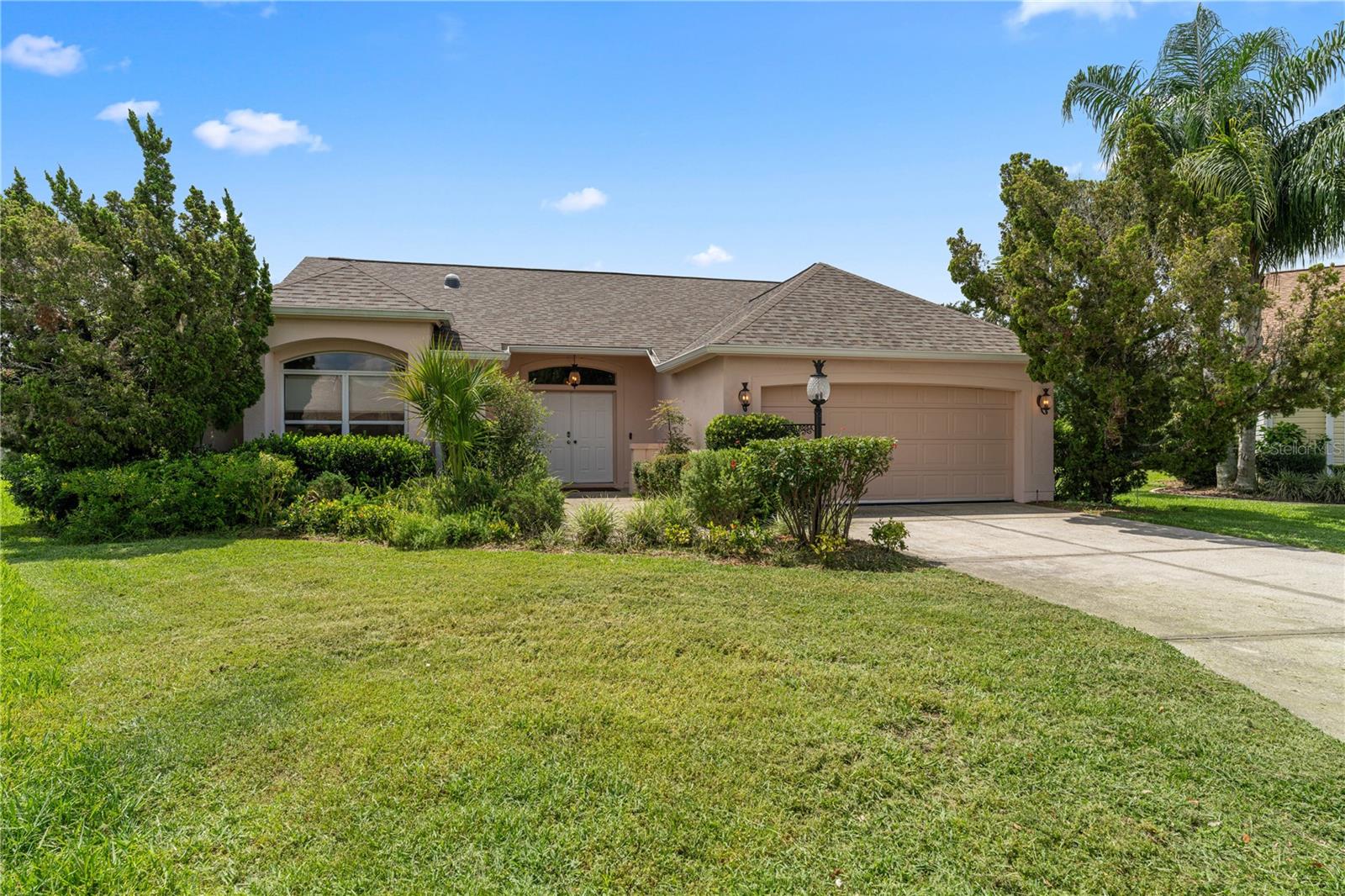 STUNNINGLY UPDATED, OVERSIZED PRIVATE LOT, 2/2 BLOCK and STUCCO BOCCA GRANDE with a POOL in the highly sought after Village of RIO GRANDE! ROOF & PREMIUM BOSCH HVAC UNIT 2023! As you approach, the ELEGANT LUSH exterior and a quaint FRONT PORCH providing a WONDERFUL OUTDOOR SPACE to RELAX and ENJOY the beautiful Florida weather! Step through the French doors, with arched transom windows, into the GENEROUS foyer featuring HIGH SMOOTH FINISH ceilings and GORGEOUS, MODERN, LUXURY WATERPROOF VINYL PLANK flooring throughout. The MAGNIFICENT kitchen is truly a sophisticated culinary space, boasting RICH PEARL cabinetry, SOLID SURFACE countertops, CUSTOM ISLAND TILEWORK and BACKSPLASH, NEW STAINLESS STEEL appliances, DESIGNER SINK, and MODERN LIGHT INSTALLATIONS. The adjacent dinette offers ample NATURAL LIGHT with double windows overlooking your PRIVATE and LUXURIOUS BACKYARD. SLEEK ELECTRIC FIREPLACE, OVERSIZED BASEBOARDS, and CUSTOM ROLL DOWN BLINDS grace the living and dining rooms. The OPEN CONCEPT floor plan and HIGH VAULTED CEILINGS of these rooms create a SPACIOUS and VOLUMINOUS main living area. DOUBLE sliding glass doors, from the living room, lead you into the FABULOUS OUTDOOR OASIS of the lanai and POOL area with A POOTERS PREMIUM CUSTOM CRAFTED POOL DECK! You will also find a MOTORIZED Kevlar Hurricane Screen.
Surrounding the pool, you will find strategically placed MATURE landscaping ensuring plenty of PRIVACY. ENJOY your own PRIVATE HAVEN as you swim in the refreshing POOL or soak up the sun on the spacious deck! NEWLY REMODELED - Renovated by Pool Inc, the exclusive contractor for The Villages — with a gleaming GLASS PERIMETER & TILE, AUTOMATED WATER-FILL SYSTEM, and bespoke design touches that evoke a private resort. That's not all! NEW HIGH-END POOL EQUIPMENT (2022) Installed by Tri County Pools, featuring a VARIABLE SPEED PUMP, SMART ELECTRIC HEAT PUMP with REMOTE access, and full safety compliance — all meeting or exceeding current building codes. Back inside, retreat to your luxurious primary suite, boasting LUXURY VINYL PLANK flooring, HIGH VAULTED ceiling, OVERSIZED WALK-IN closet, and sliding glass doors that open to the lanai and pool area. The ensuite bathroom features an exquisitely appointed retreat, this bathroom showcases FLOOR-TO- CEILING DESIGNER CERAMIC TILE that radiates refined elegance. Outfitted with a CUSTOM VANITY, MOEN DESIGNER FAUCETS, framed statement mirrors, CURATED LIGHTING, a sleek modern toilet, and an artfully TILED SHOWER AND TUB—creating a serene, spa-like atmosphere in the heart of the home.
Bedroom two offers LUXURY VINYL PLANK flooring, ARCHED TRANSOM WINDOWS, and a built-in closet. The second bathroom tastefully updated with a NEW VANITY, PEARL cabinetry, MOEN fixtures, a TILED tub and shower combination, and a hallway LINEN closet. Stepping into the TWO CAR GARAGE with EPOXY painted floors, MAYTAG WASHER & DRYER (2022), and Custom-Built, LOCKABLE STORAGE. Conveniently located 4 MIN TO SPANISH SPRINGS & 9 MIN TO LAKE SUMTER LANDING SQUARE; Close to Tierra Del Sol Country Club and Championship Golf Course; Mira Mesa Executive Golf Course; Hacienda Regional Recreation Center; Chula Vista Recreation Center; multiple pools, golf, and pickle ball; The Villages Regional Hospital; and CR 466 and Hwy 441/27 with an abundance of shopping, restaurants, banks, medical, and more! ! PLEASE WATCH OUR WALKTHROUGH VIDEO OF THIS FANTASTIC, PRIVATE, POOL HOME!