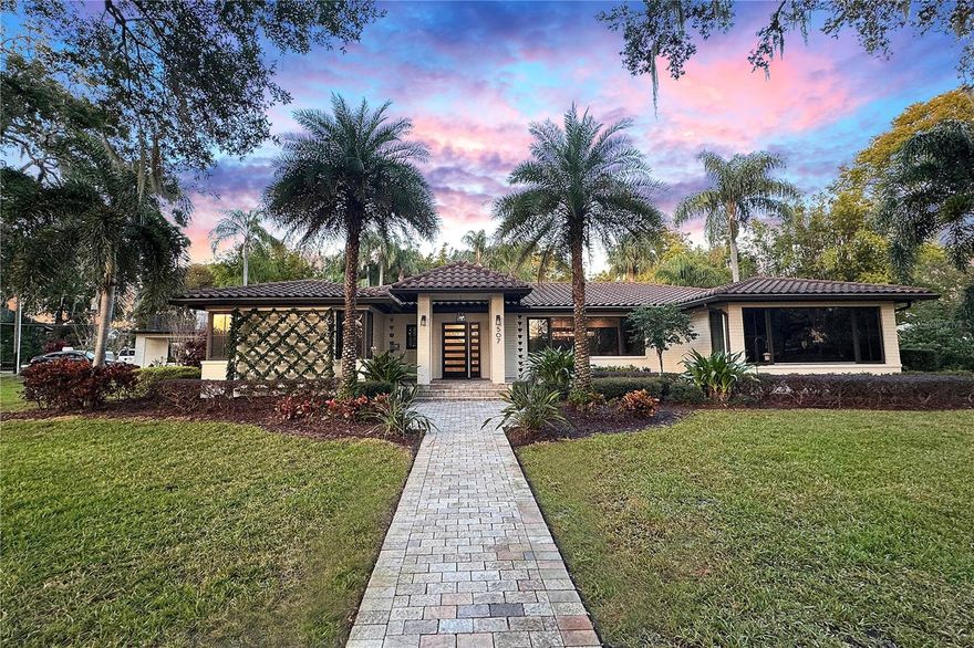 Step into your private urban oasis in the historic Lake Cherokee neighborhood, right in the heart of downtown Orlando. Nestled on a full-acre corner lot, this stunning mid-century modern ranch-style home offers the perfect blend of luxury, comfort, and convenience. Just a short walk to the Dr. Phillips Center, Lake Eola, Thornton Park, restaurants, and downtown’s vibrant business district, this one-of-a-kind property offers resort-style living at its finest.

This 5-bedroom, 4.5-bath home is surrounded by mature landscaping, including majestic oak trees, making it one of Lake Cherokee’s most beautiful properties. The completely renovated chef’s kitchen features waterfall quartz countertops, an oversized Subzero refrigerator and freezer, a Dacor appliance suite with a 48-inch range, hood, and microwave, plus a Dacor four-bottle wine dispenser, two Subzero refrigerator drawers, and a dual-zone wine fridge—everything you need to entertain in style.

For wine enthusiasts, the newly installed 1,300-bottle, temperature-controlled wine cellar with vintage view racks, custom flooring, and lighting sets the stage for unforgettable dinners. A dry bar with a cork countertop and integrated lighting enhances the dining experience. Integrated Sonos speakers throughout the home, including the outdoor living spaces, ensure seamless entertainment inside and out. The home features refinished original hardwood floors, complemented by a beautifully renovated living room with an expansive fireplace, quartz countertops, and built-in media storage.

Start each day with serene views of swans gliding across Lake Cherokee from the luxurious primary suite. The suite includes an attached office with a built-in desk, breakfast bar, and expansive his-and-hers walk-in closets. The spa-inspired primary bath boasts a soaking tub, double shower, double vanity, and a Toto smart bidet toilet. The guest bedrooms are generously sized, each with oversized closets, while the remodeled guest bath features marble, granite, and a rain shower.

The backyard feels like a secluded retreat, surrounded by mature bamboo. An outdoor kitchen, complete with a grill, ceramic searing burner, double burners, steamer, deep fryer, and wok stations, overlooks the expansive saltwater pool and spa with an outdoor shower and pool bath. The recently updated mother-in-law suite includes new floors, air conditioning, energy-efficient doors, and a gas water heater. A walkout balcony with an extended rooftop deck offers a spectacular view of Lake Cherokee.

This home has undergone significant infrastructure upgrades, including complete re-piping, new insulation, outdoor lighting, and a security gate for added privacy and peace of mind.

Don’t miss the chance to call this extraordinary property home—where modern luxury meets historic charm, all within walking distance of downtown Orlando’s best offerings. Schedule your private showing today!