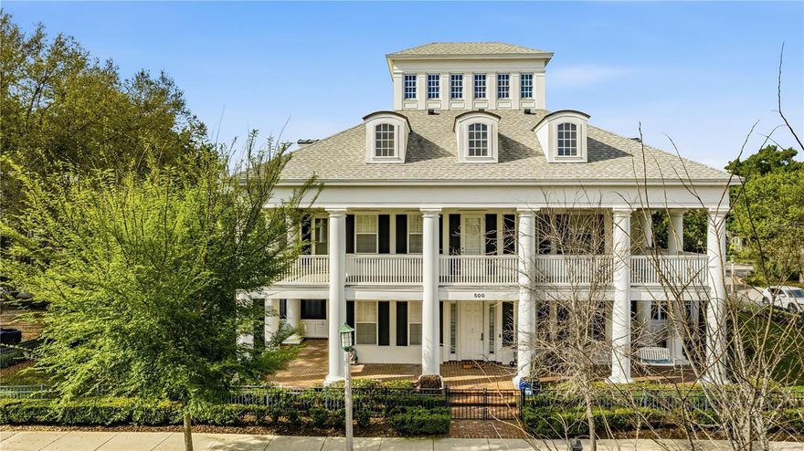 A true architectural masterpiece, this grand Southern Plantation-style estate spans an entire block, creating an unmatched sense of space, privacy, and prominence in the heart of Celebration’s Main Village. With its commanding façade, stately columns, and sweeping double wraparound porches, the home makes an unforgettable first impression from every angle—perfectly positioned on a premier corner setting just a short 5-minute walk to the town center, golf course, and K–8 school. Inspired by the historic Houmas House, this custom-built residence blends timeless elegance with modern luxury. From the rooftop cupola, enjoy breathtaking panoramic views, including stunning sunsets and nightly Disney fireworks. Inside, expansive living spaces feature a contemporary open-concept kitchen with Gaggenau and Pedini appliances, complemented by marble and hardwood flooring throughout. The outdoor retreat is equally impressive, showcasing a heated saltwater rock lagoon pool with waterfall and slide, along with a fully equipped outdoor kitchen, bar, and professional misting system—ideal for Florida living. Each bedroom offers a private, newly renovated en-suite bathroom, while upgraded hybrid water systems and instant hot water pumps ensure comfort and efficiency. A private elevator connects all levels, leading to the spectacular fourth-floor cupola. Encircling the home, the impressive 1,600-square-foot double wraparound porch enhances both its grandeur and livability. A detached one-bedroom apartment with private entrance provides flexibility as a guest suite, home office, or income-producing rental. Completing the estate are two separate garages connected by a beautifully paved brick courtyard. This rare full-block property delivers a level of scale, location, and architectural presence that is truly unmatched in Celebration.