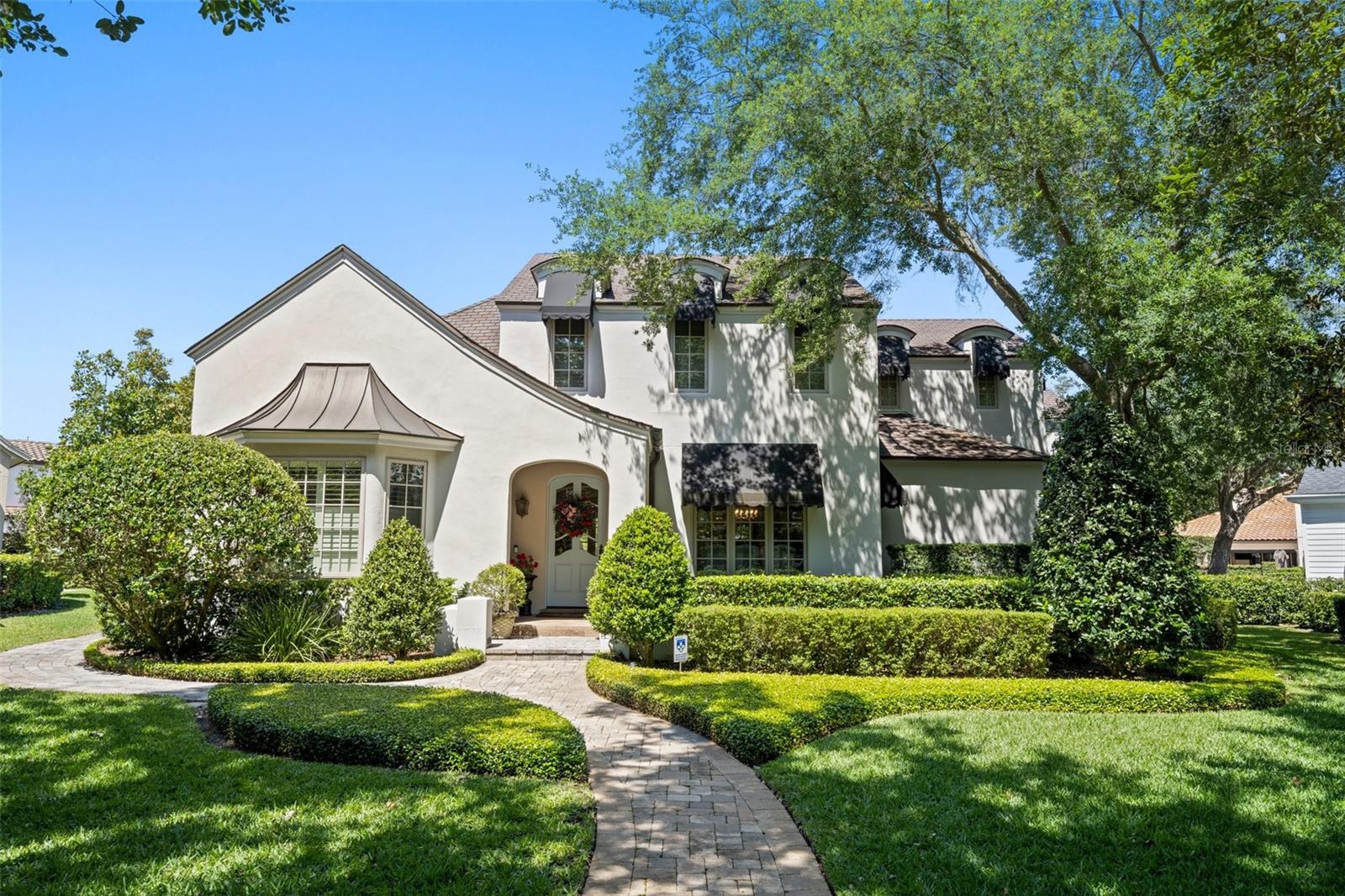 This exquisite French Country estate is a true masterpiece, boasting a grand total of 4900 square feet of luxurious living space. Located in the highly coveted Penn Place neighborhood and within walking distance to the lively shops and restaurants of Park Ave, this property offers the perfect combination of peaceful serenity and urban convenience.
Situated on a quiet cul-de-sac overlooking the park, this home boasts stunning curb appeal with a paver driveway leading to a three-car rear load garage. The first floor features high vaulted ceilings and gorgeous wood flooring, creating an inviting and warm atmosphere throughout. The gourmet kitchen is every chef's dream, complete with top-of-the-line appliances and custom cabinetry. Adjacent to the kitchen is the perfect space for hosting family dinners or entertaining guests.
The master suite, located on the first floor, offers a luxurious retreat with a large master bath, soaking tub, and separate shower. Upstairs, you'll find two separate quarters - one perfect for use as an in-law suite or game room, complete with an additional bedroom and bathroom. The other quarter features two bedrooms, one and a half bathrooms, and a private office.
Step outside and be transported to a tropical oasis, with lush and vibrant landscaping surrounding the property. The outdoor space features a beautiful pool and spa, perfect for relaxing or hosting outdoor gatherings. For golf enthusiasts, the backyard also boasts a putting green, allowing you to practice your swing in the comfort of your own home.
Don't miss your opportunity to own this one-of-a-kind property in the heart of Winter Park.
