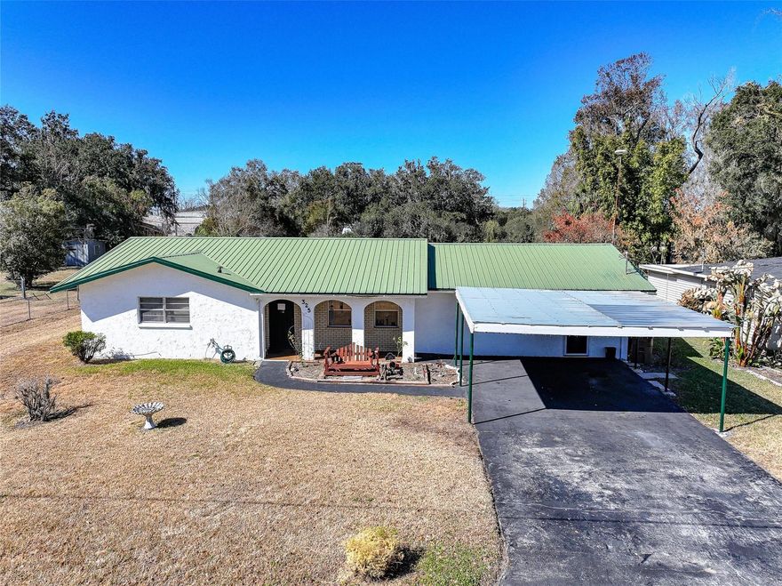 This one just makes sense. Three bedrooms. Two bathrooms. Solid concrete block construction with a metal roof overhead so you can sleep easy when the Florida storms roll in. A two-car carport out front and a backyard big enough for birthday parties, garden beds, a swing set, or finally getting that dog you keep talking about. Inside, the layout is open and easy. The kitchen gives you plenty of cabinet space and generous countertops so you’re not playing Tetris every time you cook dinner. The bedrooms are all comfortably sized, and the bathrooms are clean and full of character with vintage tile details that feel classic instead of cookie-cutter. And then there’s the bonus room. Not a “tiny flex space.” Not a “maybe it fits a desk.” A MASSIVE bonus room. Game nights. Home gym. Movie room. Hobby space. Fourth bedroom. Second living room. You name it. This is the kind of space that grows with you instead of boxing you in. There’s also an extra-long laundry and utility room with room to actually move around and store the things that real life requires. Location? You’re right where you want to be. Quick access to everything we love about Wauchula. Downtown charm, local schools, shopping, and the everyday conveniences that make life easier. Solid. Spacious. Well located. And full of possibility.