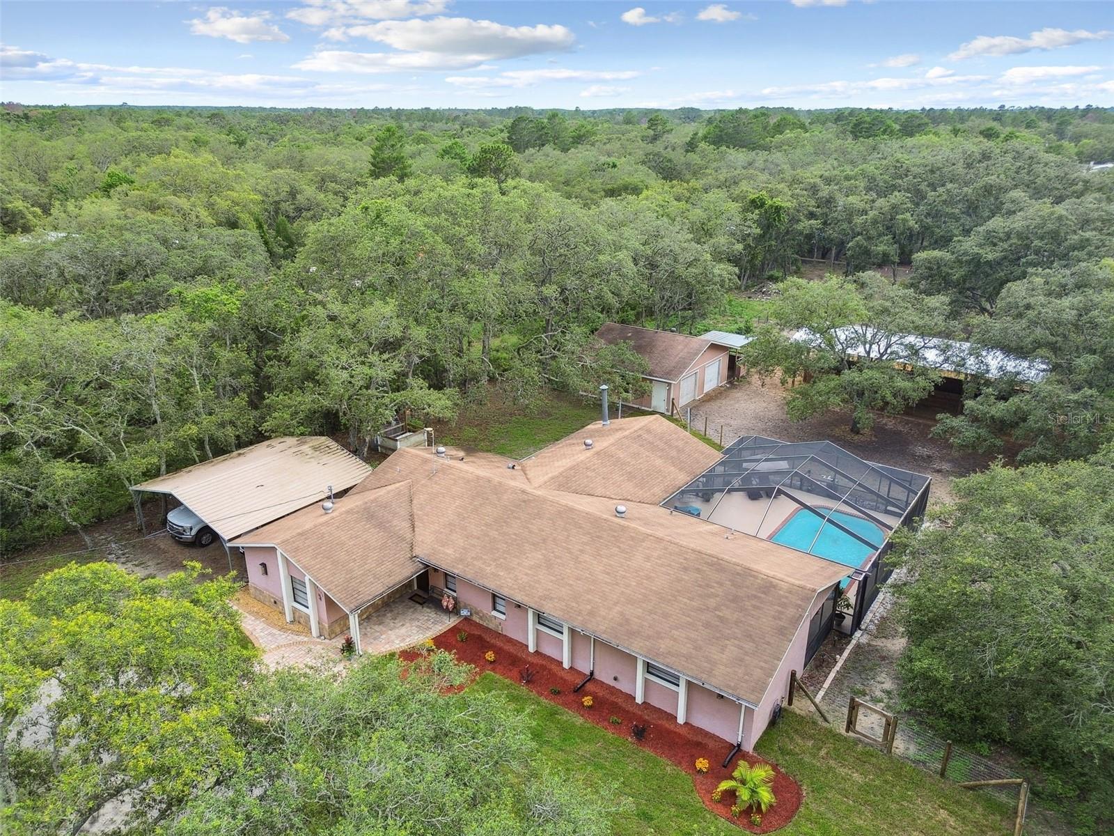 Equestrian Paradise on Nearly 4 Acres in Hudson!!!! Welcome to an exceptional equestrian property offering the ideal blend of country charm and modern functionality. Situated on just under 4 fully fenced and cross-fenced acres, this private estate is thoughtfully equipped for horse enthusiasts, hobby farmers, or those seeking a tranquil rural lifestyle. The centerpiece of the property is a recently constructed 4-stall barn featuring electric, ceiling fans, and automatic Nelson waterers—designed to meet the highest standards of equine care. Multiple pastures provide ample space for grazing, and a gated entrance ensures privacy and security throughout the grounds. The residence itself is a beautifully maintained 3-bedroom, 2.5-bath pool home with an open-concept layout, vaulted ceilings, and abundant natural light. The remodeled primary suite offers a luxurious retreat with dual vanities, an oversized walk-in shower, dual closets, and a dedicated office with serene pool views. Outside, enjoy a resort-style atmosphere with a covered patio, sparkling pool, outdoor shower, and a poolside half bath—perfect for entertaining. Additional features include a detached 2-car garage, mature trees, and impressive curb appeal. Whether you're an avid equestrian, a nature lover, or simply seeking a peaceful setting with top-tier amenities, this Hudson property is a must-see. Schedule your private tour today.(ROOF-2013)(A/C-2022)(W/H-2022)