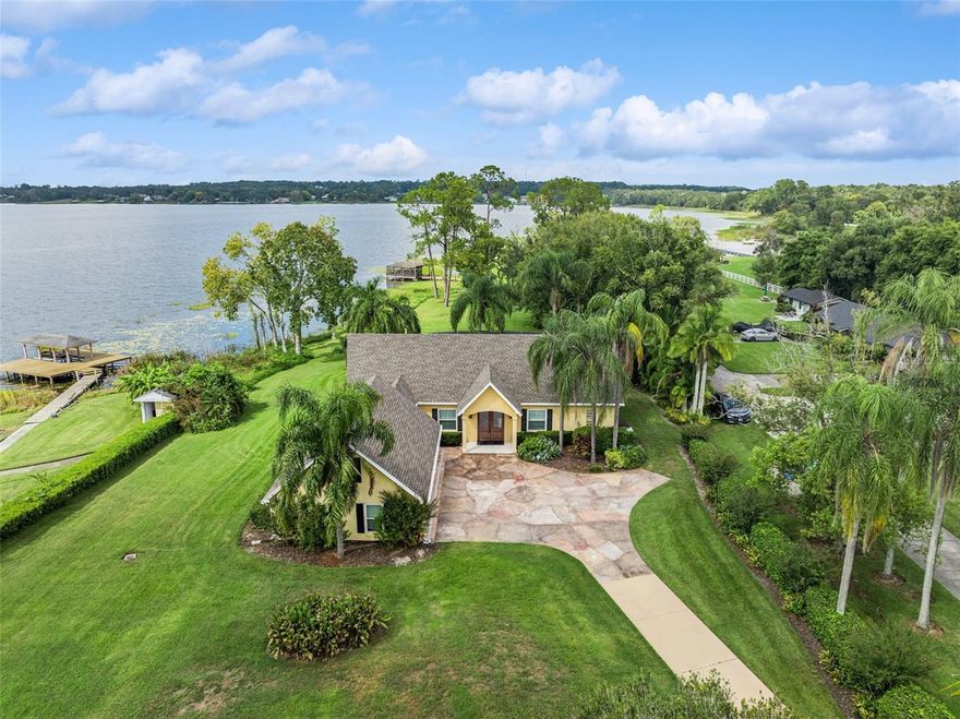 WATER FRONT LAKE HOUSE WITH BOAT HOUSE AND SECOND WATERFRONT PARCEL!!! Here is a Rare opportunity to own on Lake Ola, with an additional adjacent water-front parcel included in the sale. This stunning waterfront property features its own screened-in boat house with a boat lift, perfect for evenings on the water. This custom home overlooks a pristine swimming pool and Lake Ola, a striking 426-acre spring-fed jewel. Main level highlights include an exceptional primary suite with a bonus room accessed directly from the primary bath. The home gleams with plantation shutters and numerous tasteful finishes. Upstairs, you'll find two additional bedrooms (one with a private balcony overlooking the lake) and a welcoming second living area for guests. A standout is the bonus room above the garage, an unexpected hidden gem. The current owners acquired the neighboring parcel and removed the existing home to enhance the property's beauty. The extra land offers versatile possibilities: preserve as-is, or develop into a multi-generational living space, guest suite, garage, or rental opportunity. This is a rare lakeside gem on Lake Ola, your waterfront dream awaits. 2024 Roof, 2018 Windows and Doors. 2013 and 2016 AC units. Security cameras on site (by appointment only please) property is occupied.