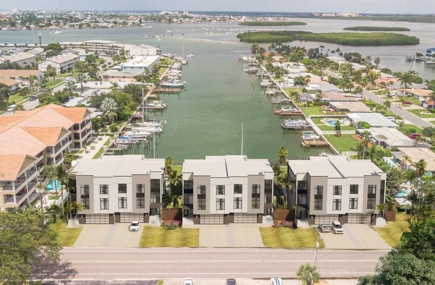 COMPLETED NEW CONSTRUCTION – PRICE REDUCTION!!  Move-in ready and hurricane-tested, offering proof that elevated construction works. Located in one of the most coveted boating areas in Pinellas County, this property offers breathtaking down-canal views of Boca Ciega Bay and the John's Pass Sandbar gathering area. Designed by teams featured on HGTV’s "Rock the Block" (Season 5), the home blends luxury, durability, and functionality in every detail. Built 16 feet above grade to exceed modern flood-zone codes, this block construction home features a commercial-grade membrane roof, hurricane-impact windows and doors, and 11-foot ceilings throughout. The designer chef’s kitchen boasts high-end finishes, upgraded Kohler fixture package, custom solid wood cabinets, quartz counters, Bluestar custom refrigerator, Bluestar 8 burner gas stove with dual oven and built-in stainless-steel hood, butler’s pantry, dumb waiter, and much more. Walls of windows flood the interior with natural light and frame stunning waterfront views. Expansive indoor and outdoor entertaining areas include a private heated pool and spa with a sun shelf, as well as a brand-new boat dock. The four-car tandem garage has dual front and rear garage doors for easy access. An elevator option is also available for added accessibility. The building is a duplex and each unit lives like a single-family home but with less maintenance.  Each residence includes its own fenced yard, private resort-style pool, and boat slip. Offered fully furnished or unfurnished, this home is ready for immediate move-in. Bring your boat and enjoy the best of waterfront living!